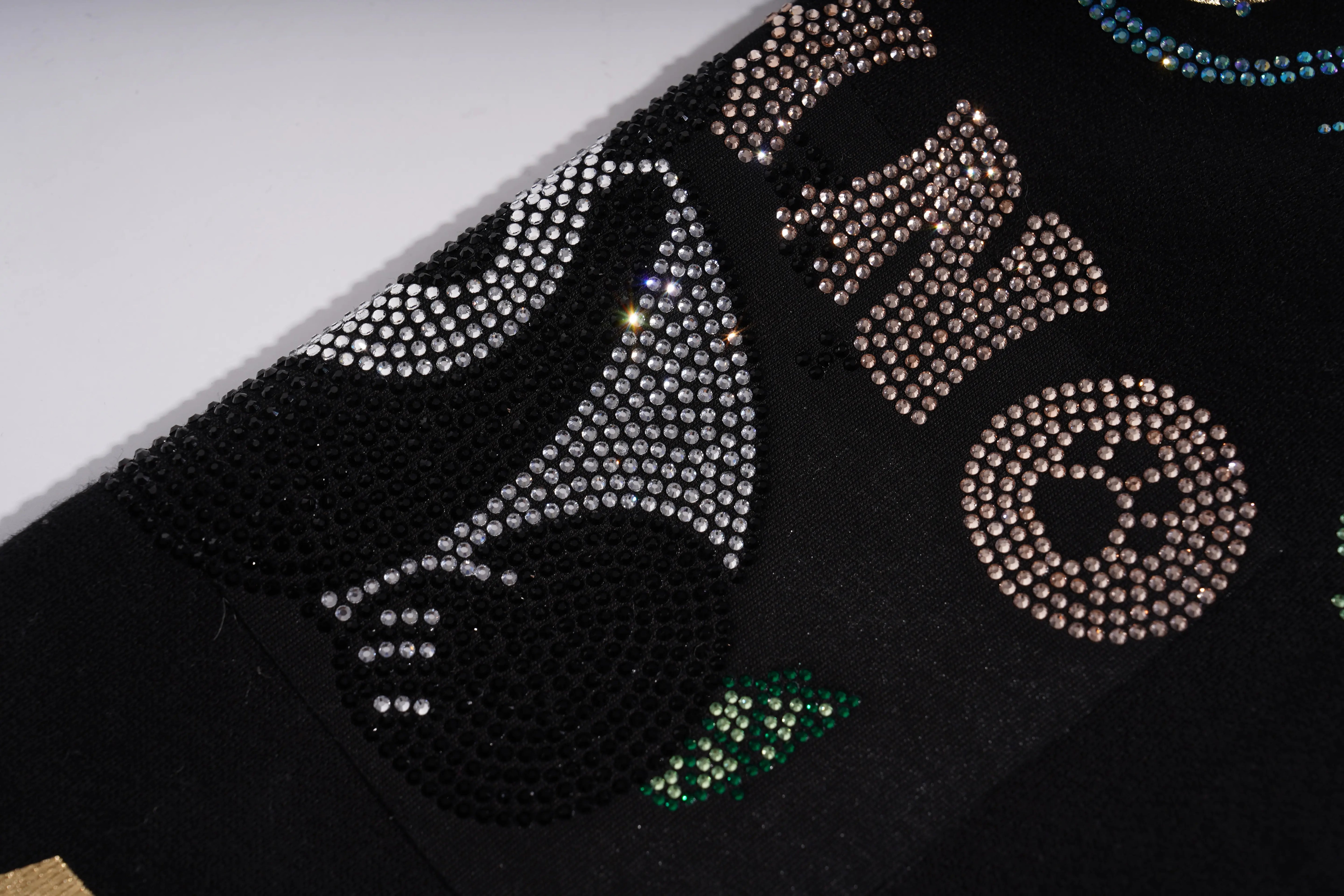 Close-up of a black surface with decorative elements featuring rhinestones and patterns. TCH Panda Rhinestone Black Jogger Pants