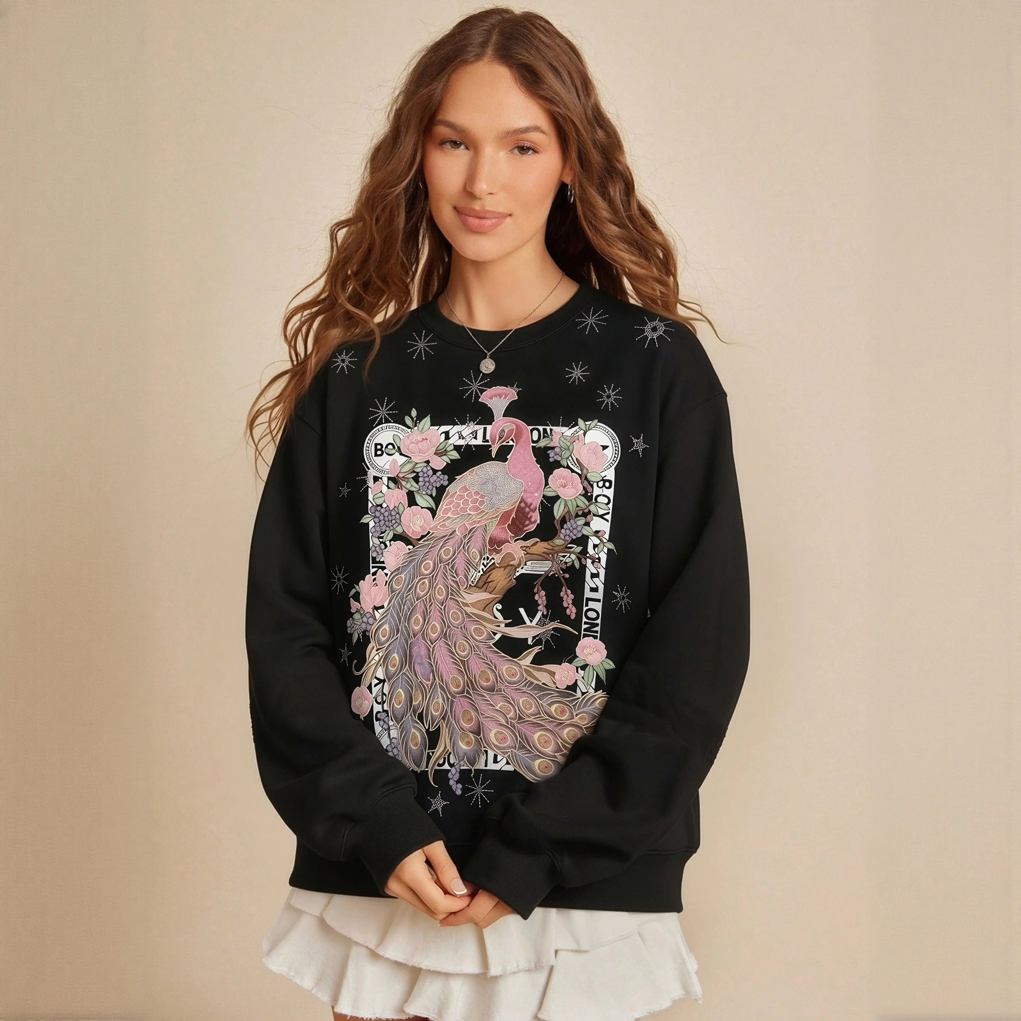Woman wearing a black sweatshirt with a peacock design on a beige background， TCH Peacock Embroidered Rhinestone Sweatshirt-