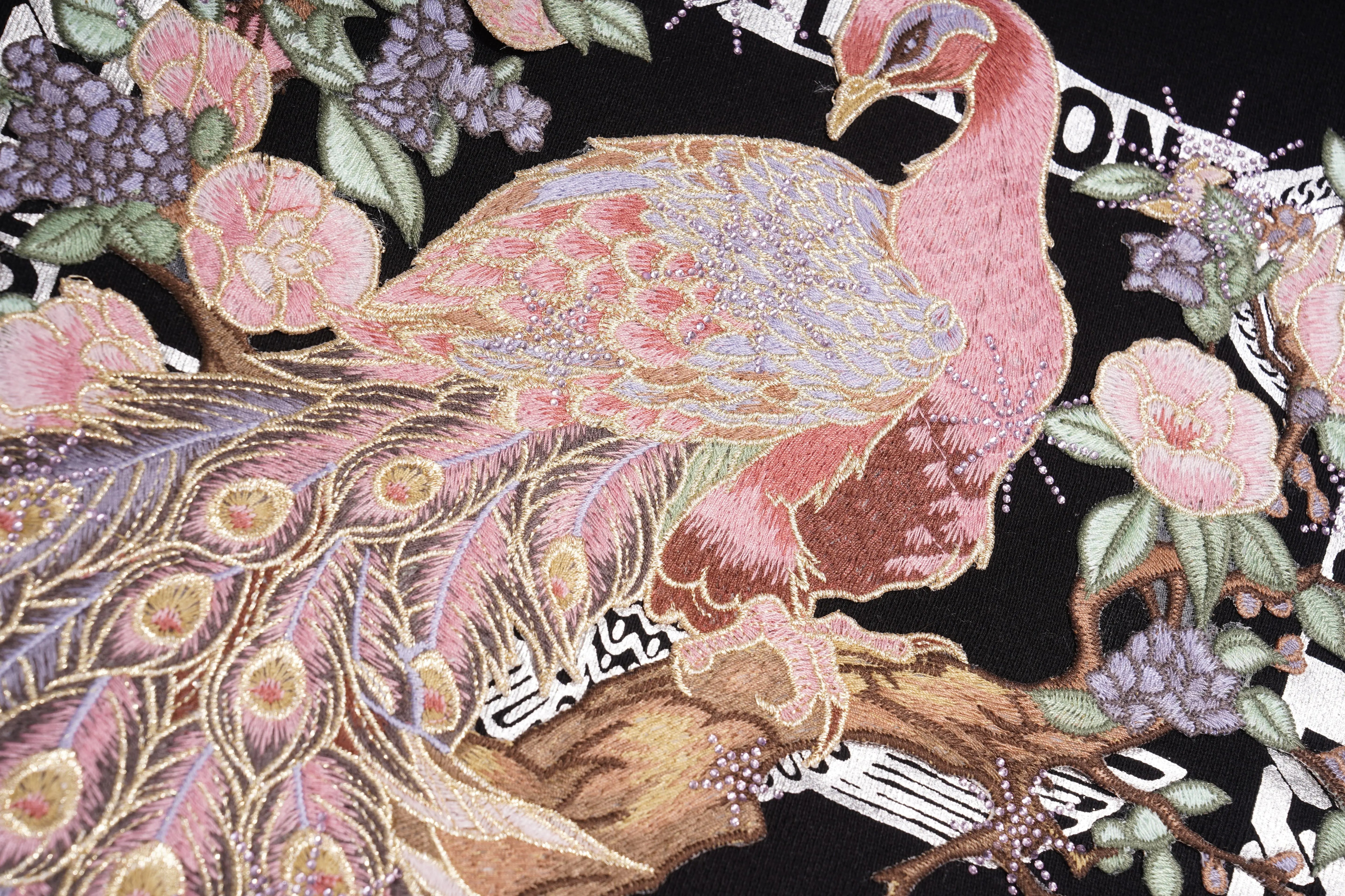 Decorative fabric with a peacock design and floral elements on a black background， TCH Peacock Embroidered Rhinestone Sweatshirt