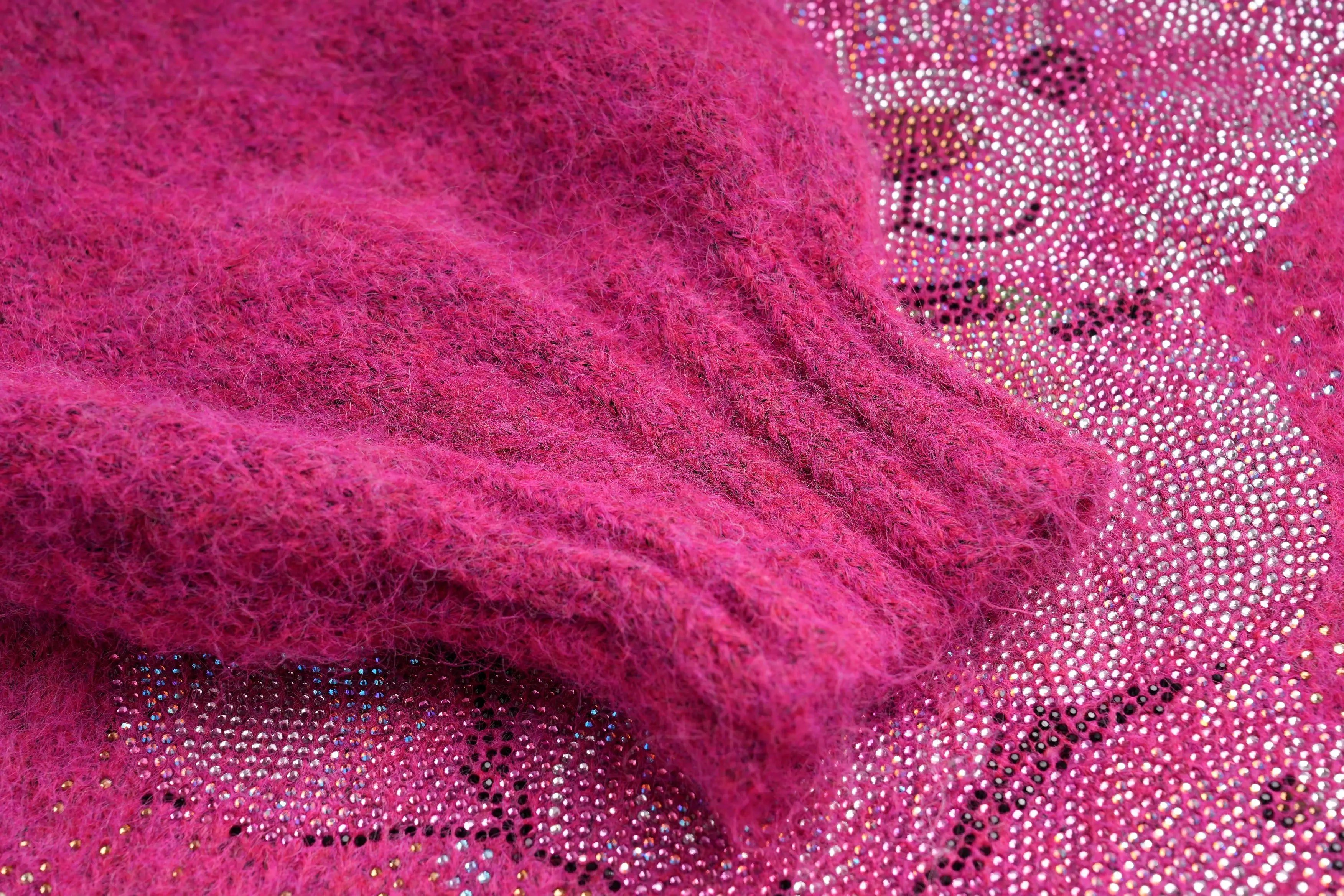 Close-up of a pink textured fabric with a patterned background, TCH Pink Rhinestone Bear Knit Cardigan