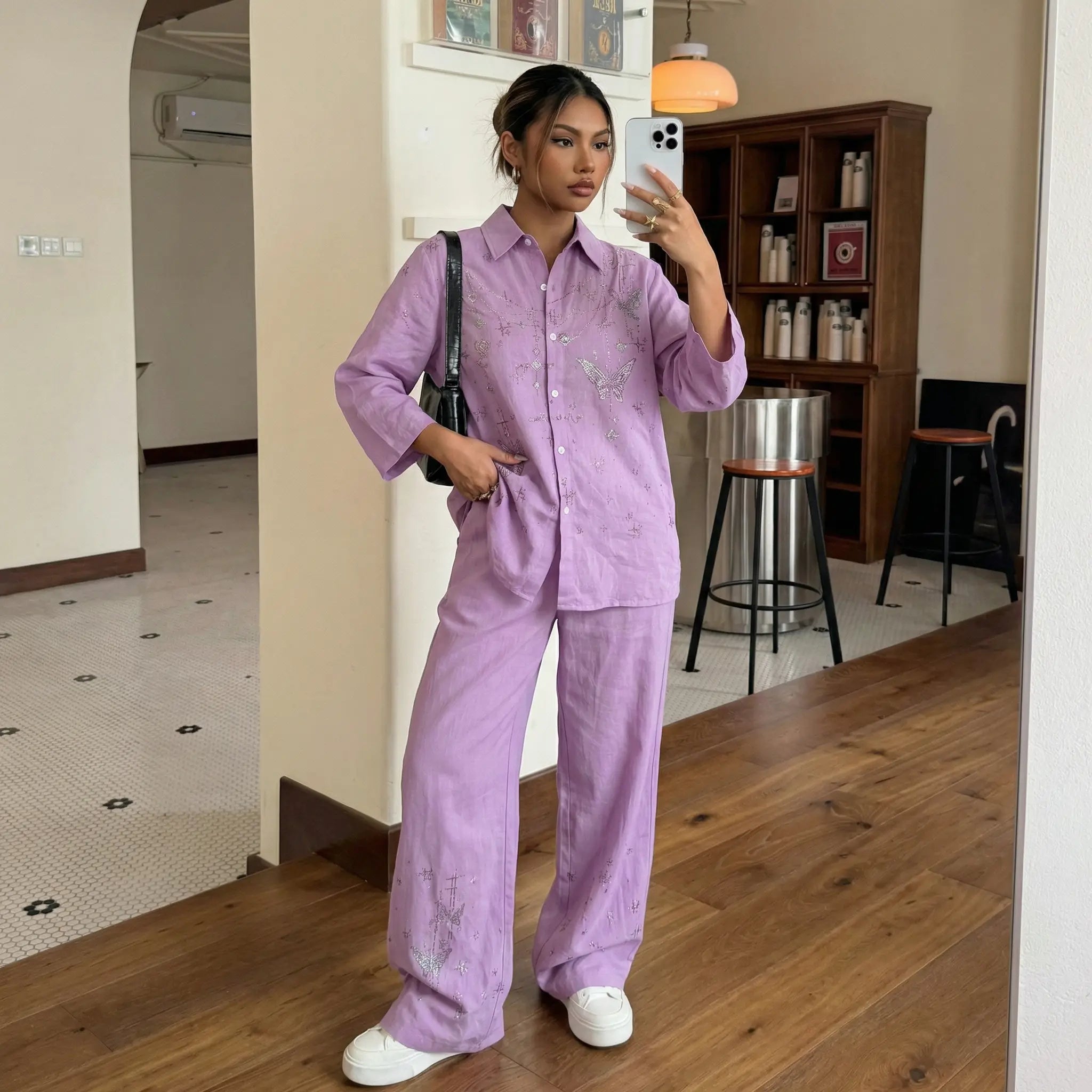 Woman taking a mirror selfie wearing a purple outfit in a room with wooden flooring and a bookshelf. TCH Purple Rhinestone Butterfly Set