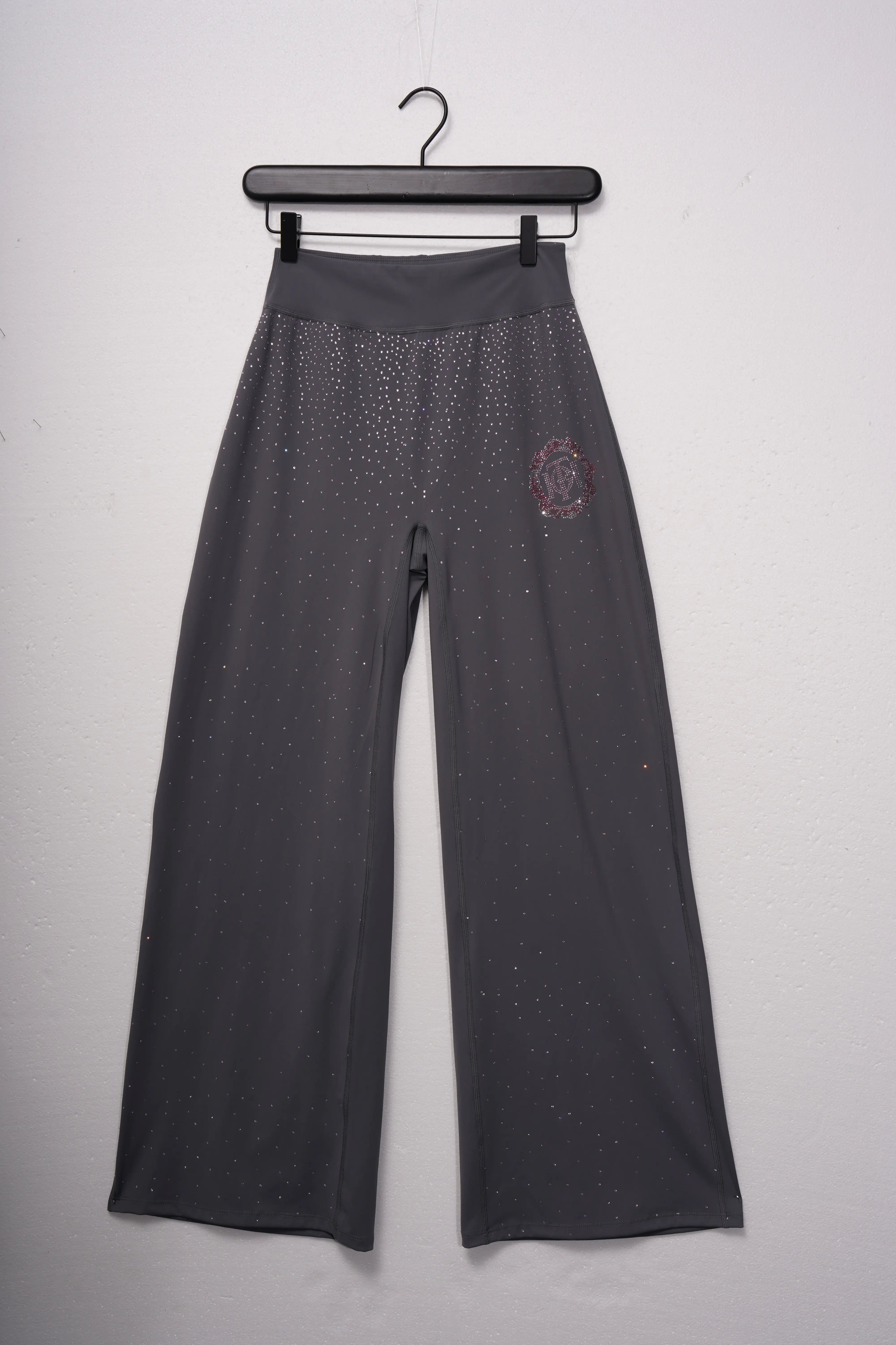 Dark gray pants with a small logo on a hanger against a light gray background, TCH Purple Rhinestone Gradient Sweatpants