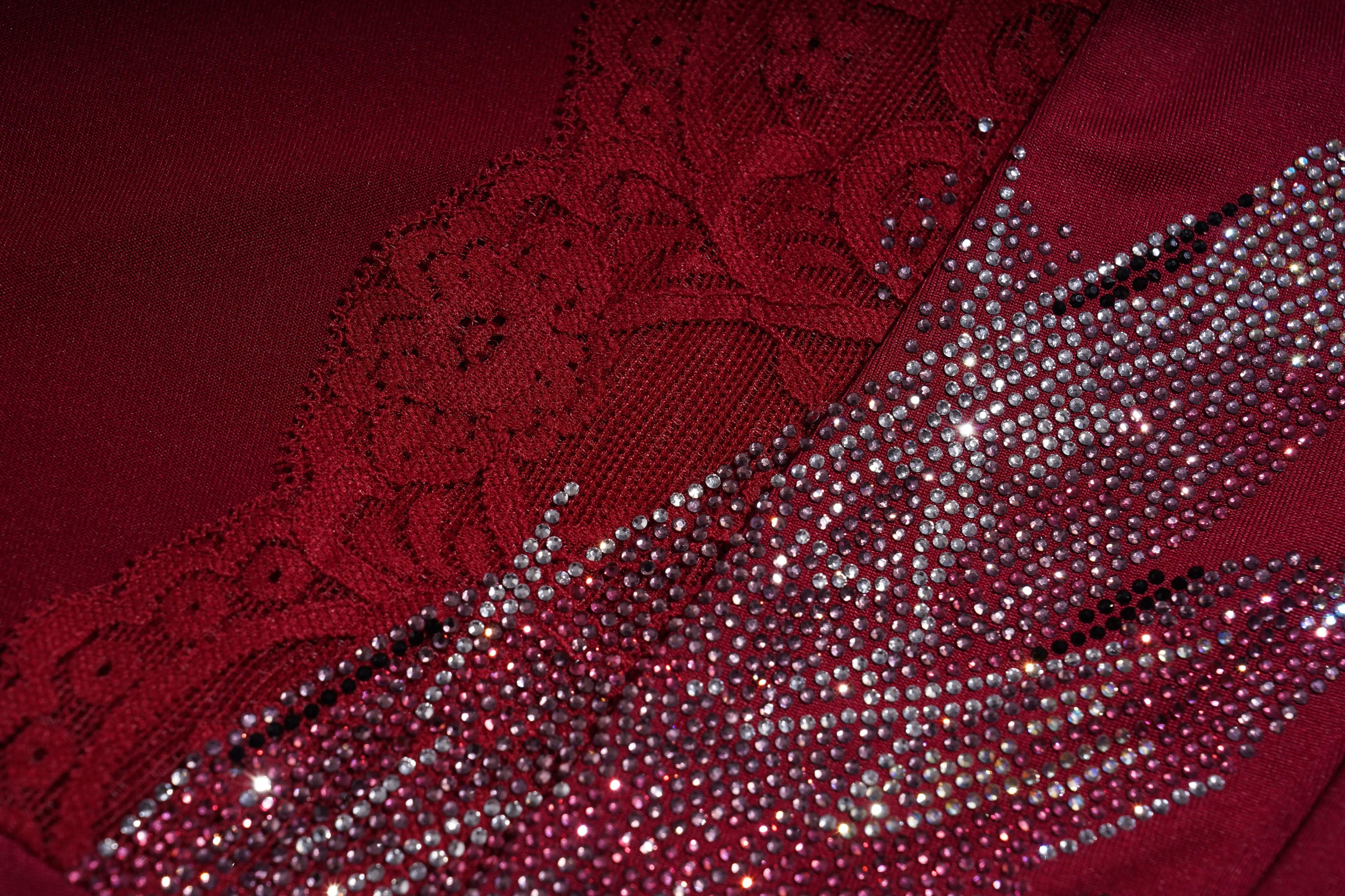 Close-up of red fabric with lace and sequin details, TCH Red Lace Trim V-Neck Rhinestone Wing Long Sleeve Top