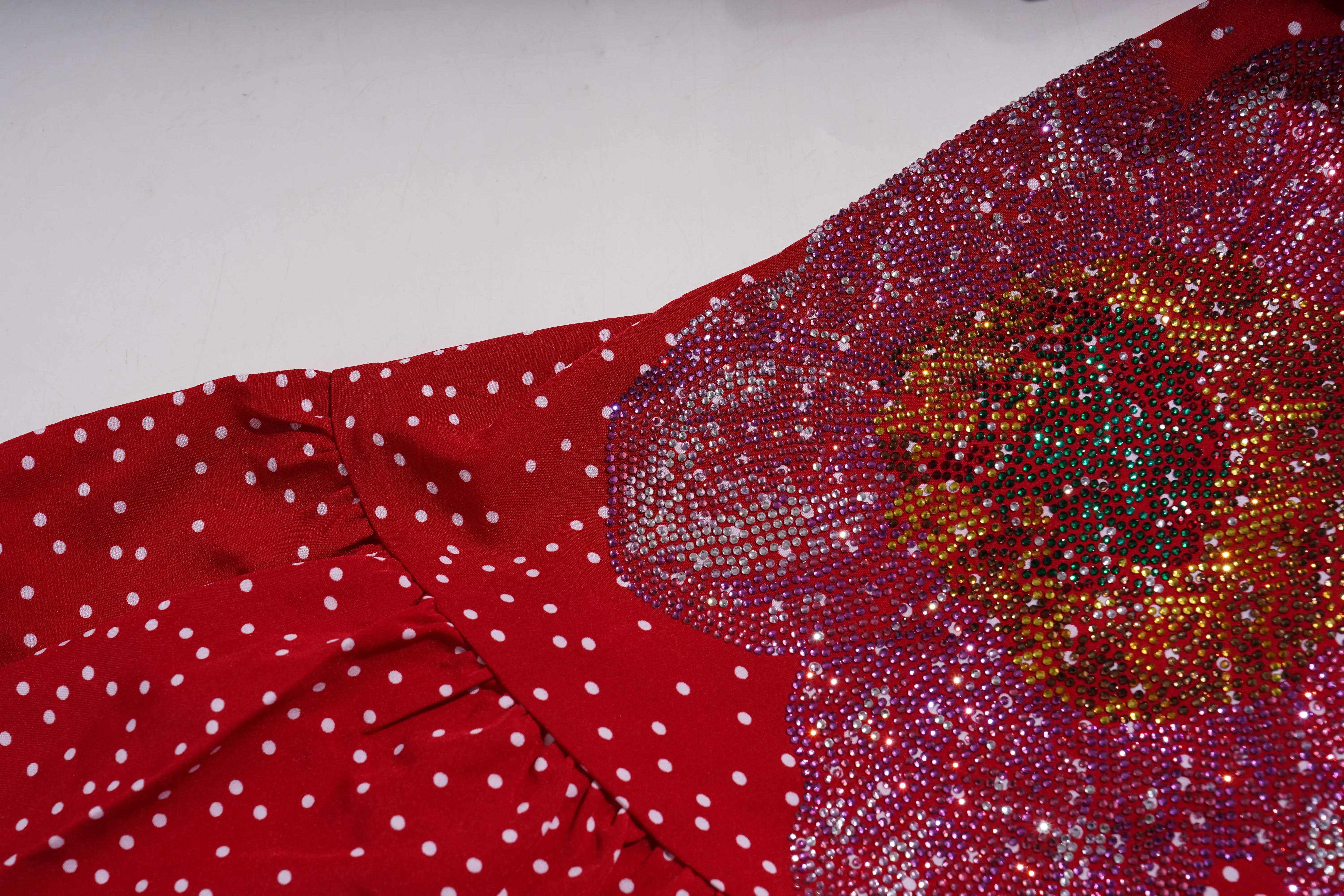 Red fabric with white polka dots and a floral pattern with sequins on a gray background, TCH Red Polka Dot Rhinestone Flower Dress