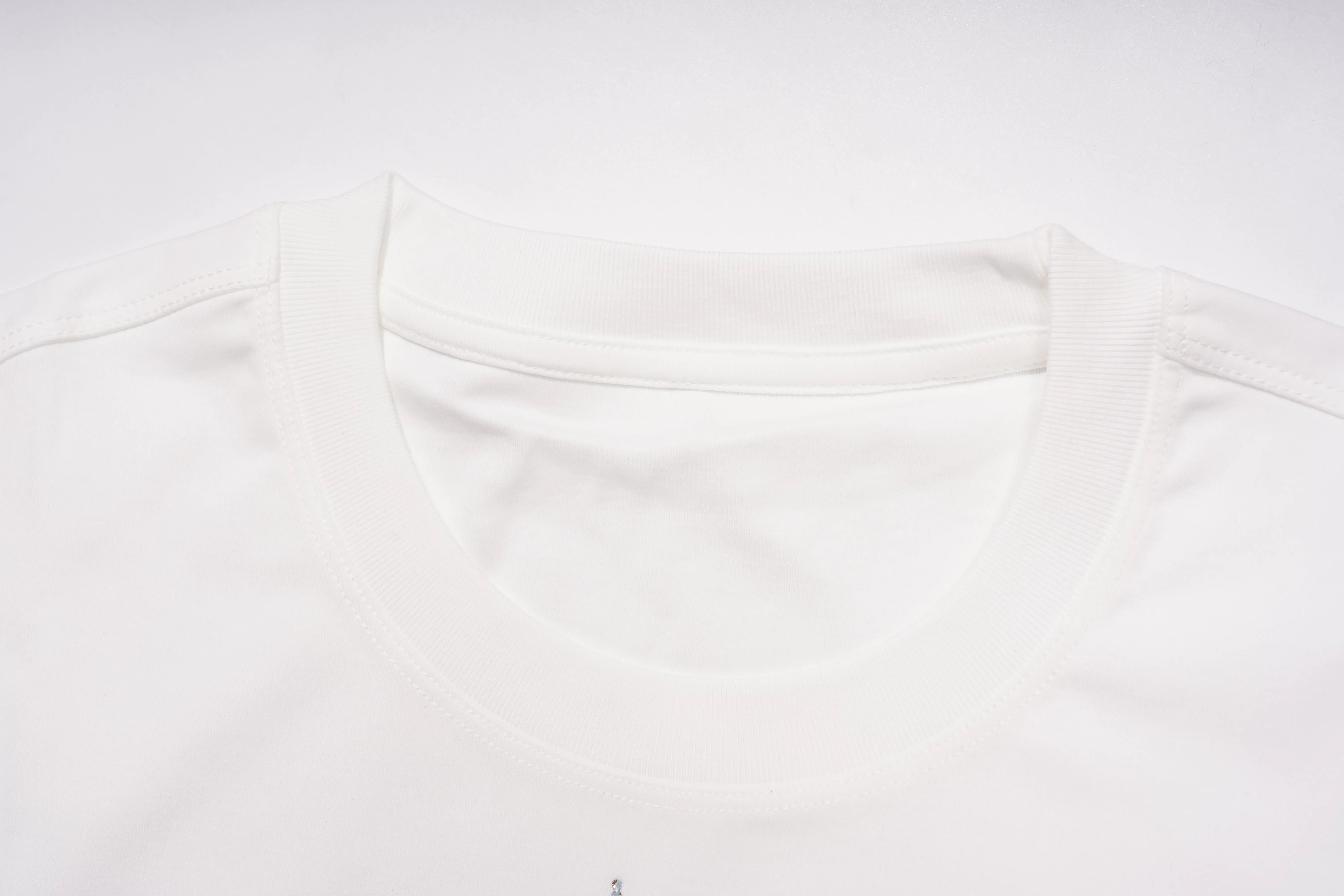 Close-up of a white crew-neck t-shirt showing the inner collar lining and ribbed neckline against a white background. TCH Regal Crown Lion Rhinestone Graphic T-Shirt