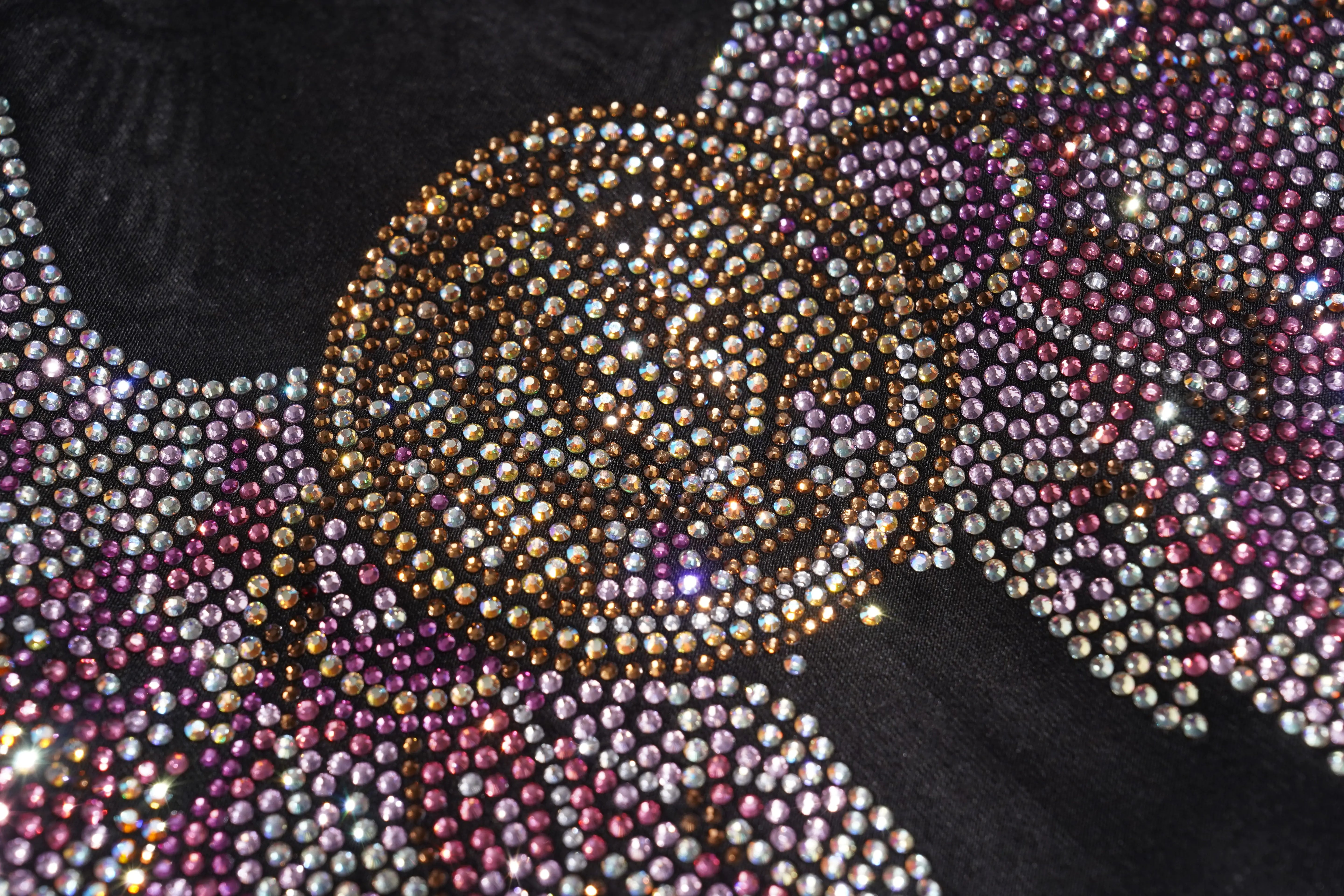 Close-up of a decorative fabric with rhinestones and floral patterns. TCH Rhinestone Angel Wing Black Dress