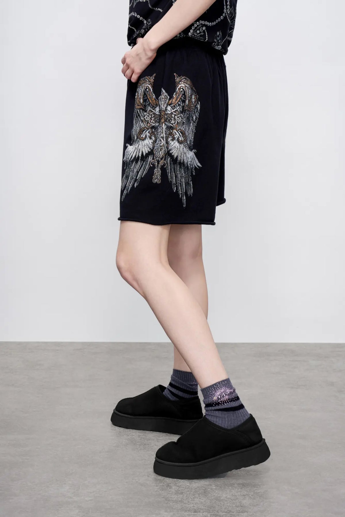 TCH Rhinestone Angel Wings Black Sweat Shorts TCH angel wings shorts Rhinestone black sweat shorts Black graphic shorts Angel wing sweat shorts Embellished black shorts Rhinestone streetwear shorts Y2K black shorts Relaxed fit sweat shorts Gothic graphic shorts Black casual drawstring shorts