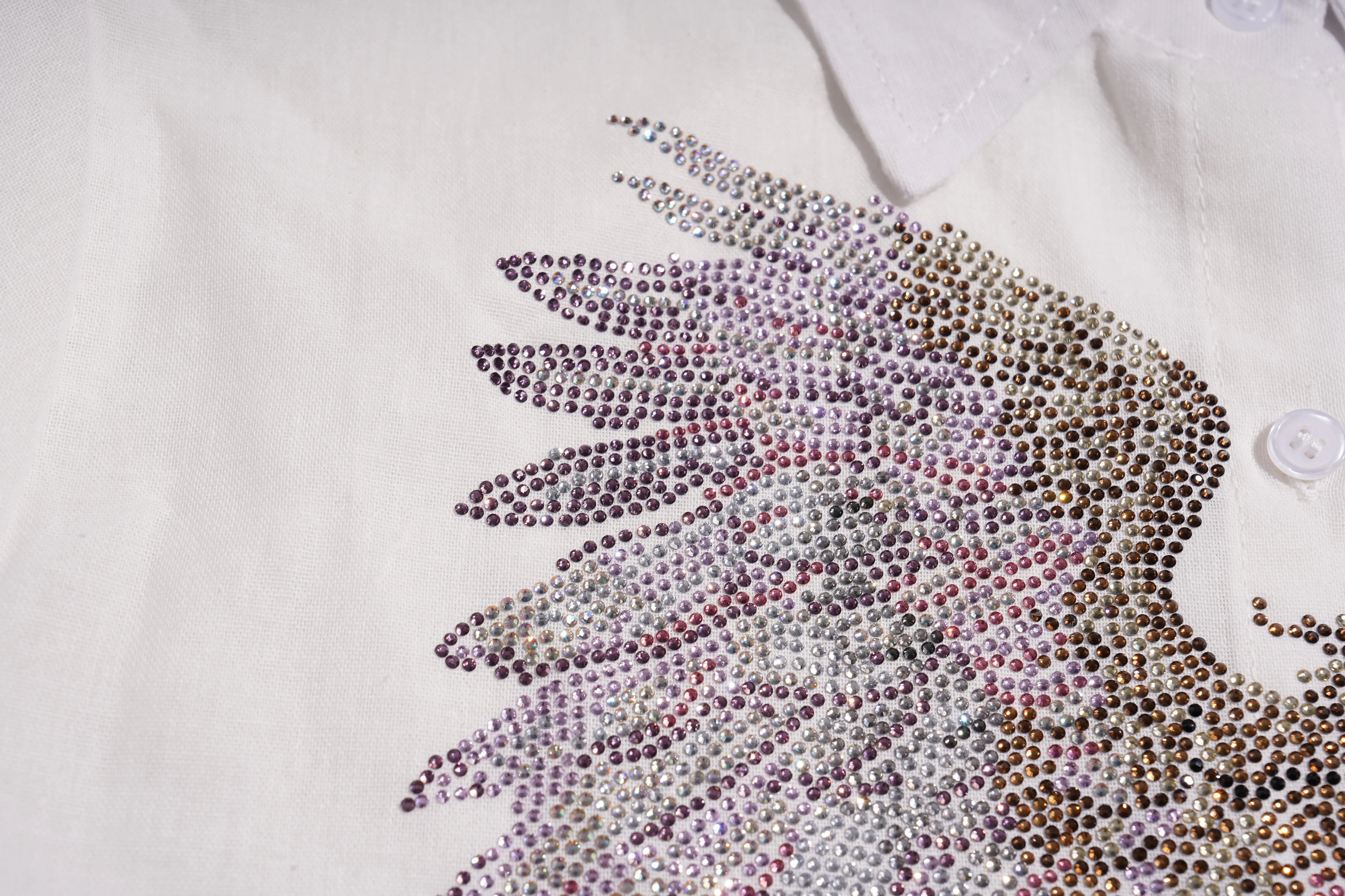 Close-up of a decorative rhinestone design on a white shirt. TCH Rhinestone Angel Wings & Cross Set