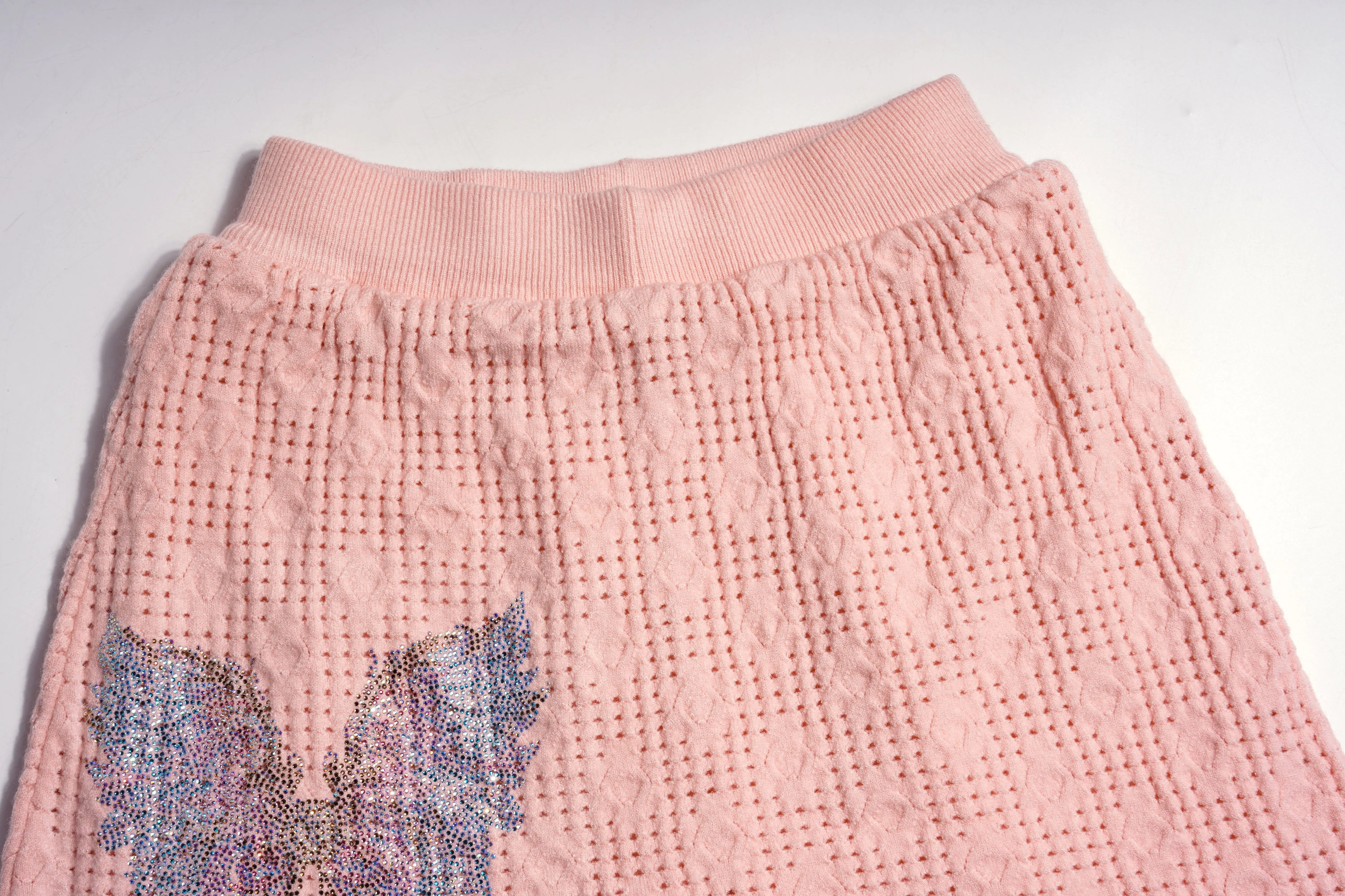 Close-up of pink textured fabric with a butterfly design on a white background, TCH Rhinestone Angel Wings Layered Knit Top & Wide-Leg Pants Set