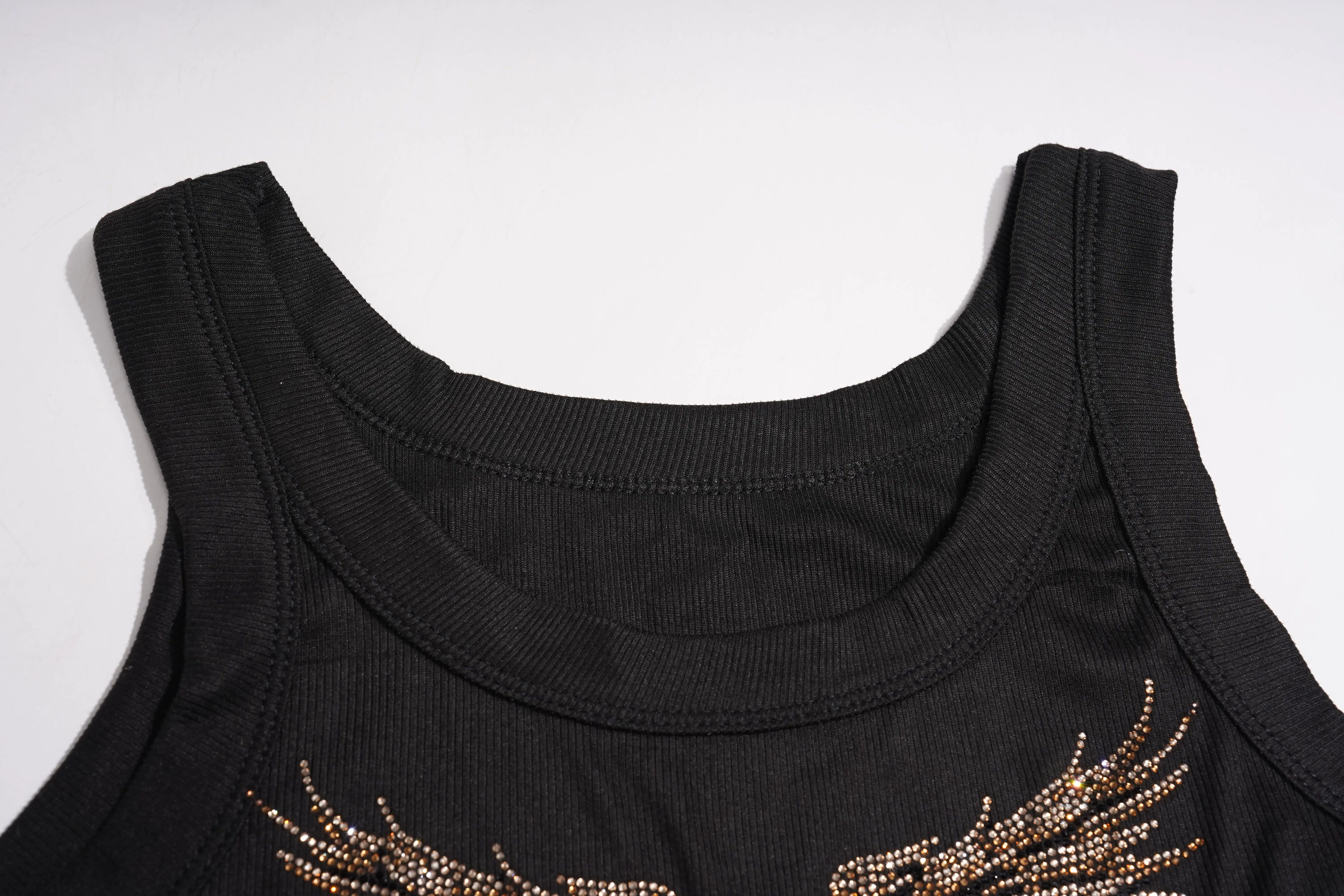 Close-up of a black knit garment cuff with a white double stripe trim, shown on a light gray background. TCH Rhinestone Angel Wings Ribbed Tank Top 
