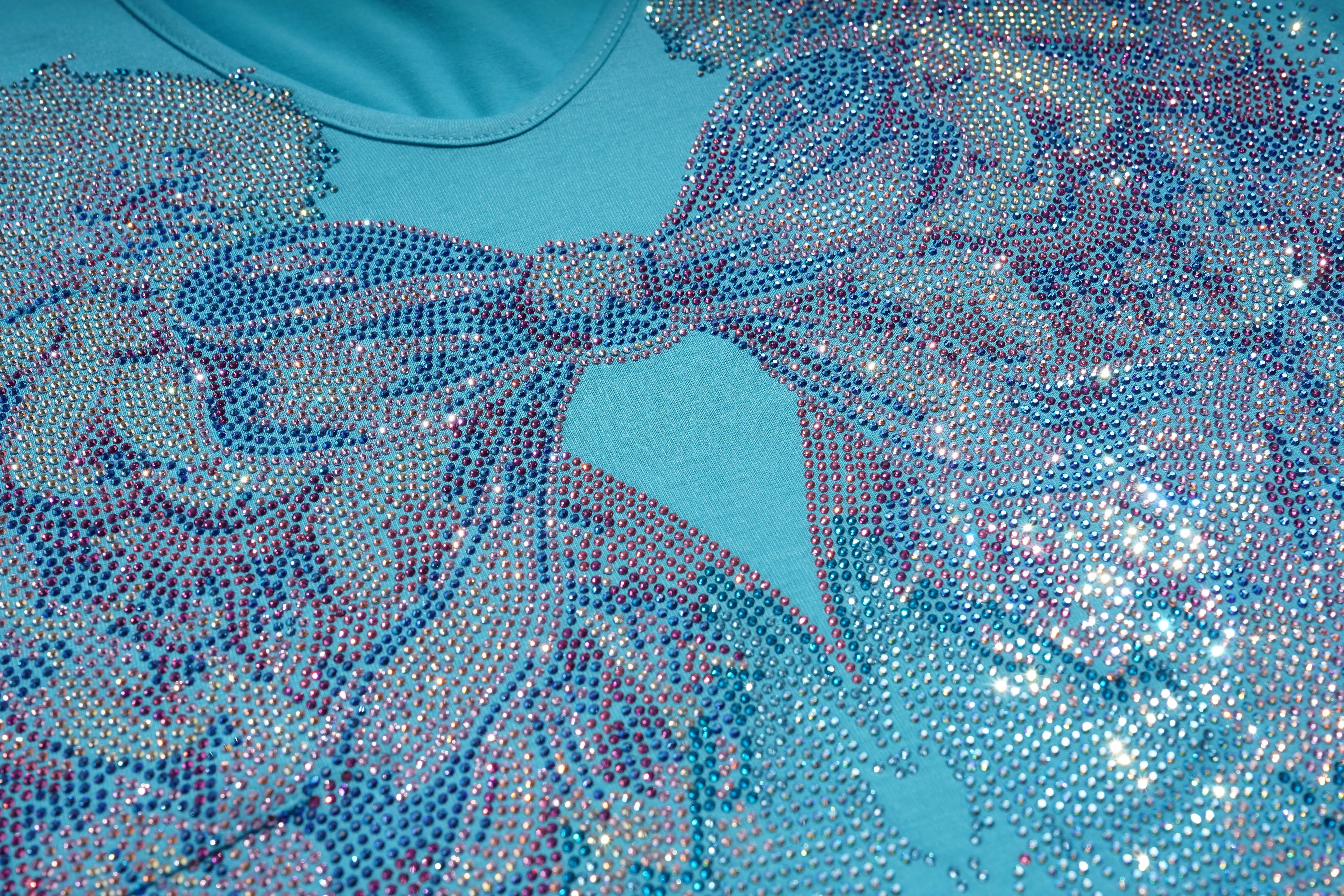 Close-up of a blue dress with intricate beadwork and a bow detail. TCH Rhinestone Angel Wings V-Neck T-Shirt