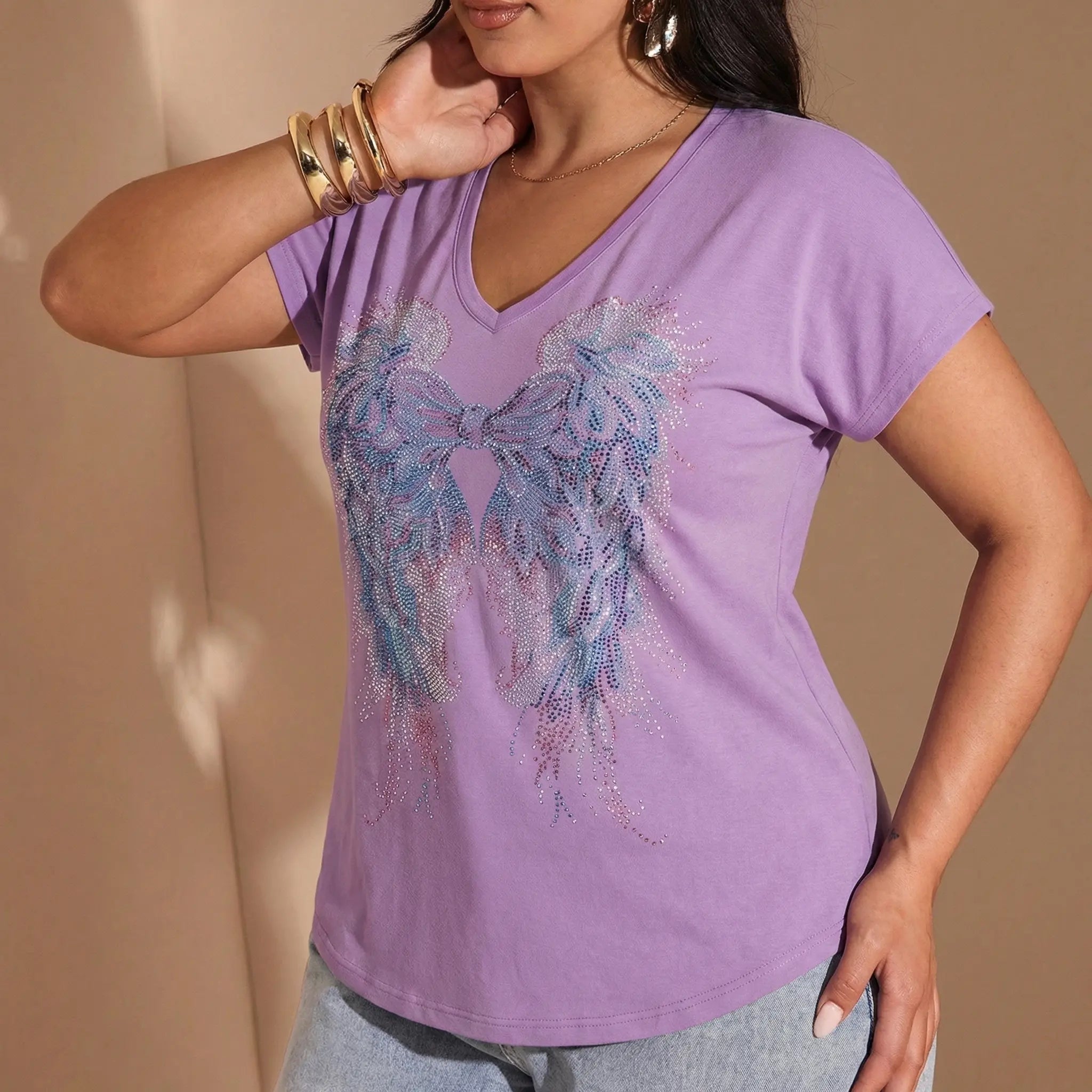 Woman wearing a purple t-shirt with a decorative design on a beige background, TCH Rhinestone Angel Wings V-Neck T-Shirt