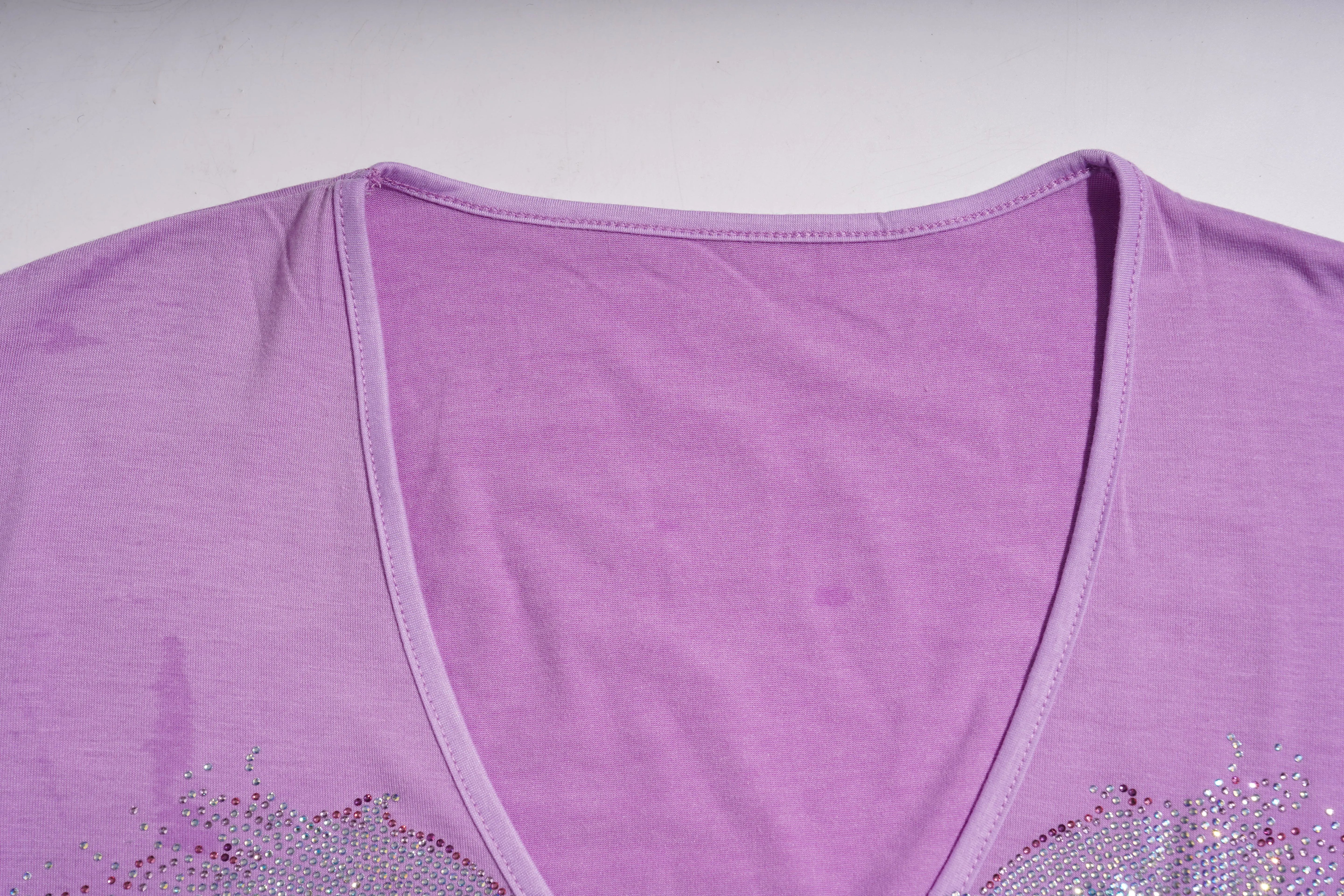 Close-up of a purple top with decorative elements on a light gray background, TCH Rhinestone Angel Wings V-Neck T-Shirt