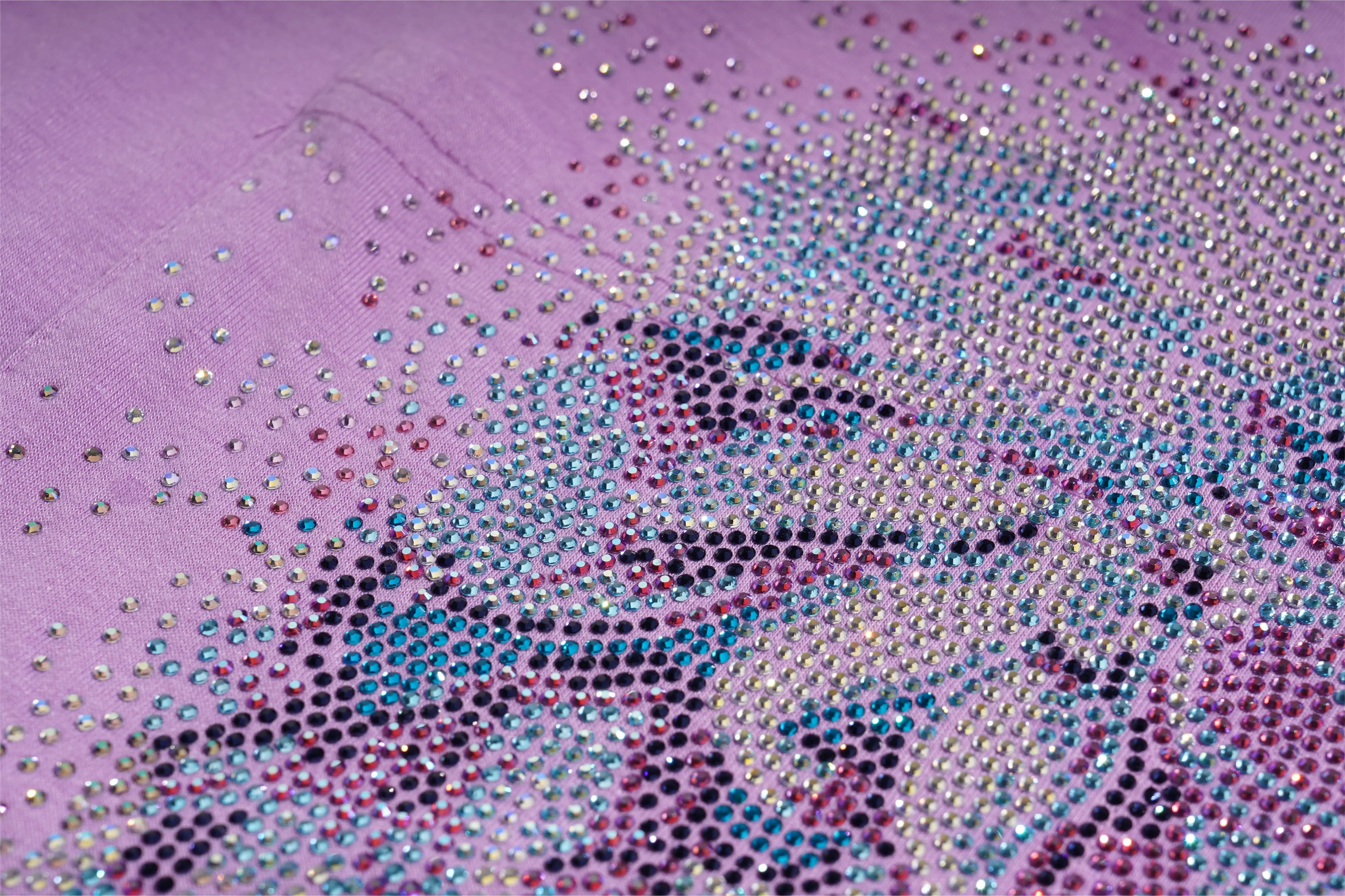 Close-up of a pink fabric with a pattern of small, multicolored rhinestones. TCH Rhinestone Angel Wings V-Neck T-Shirt