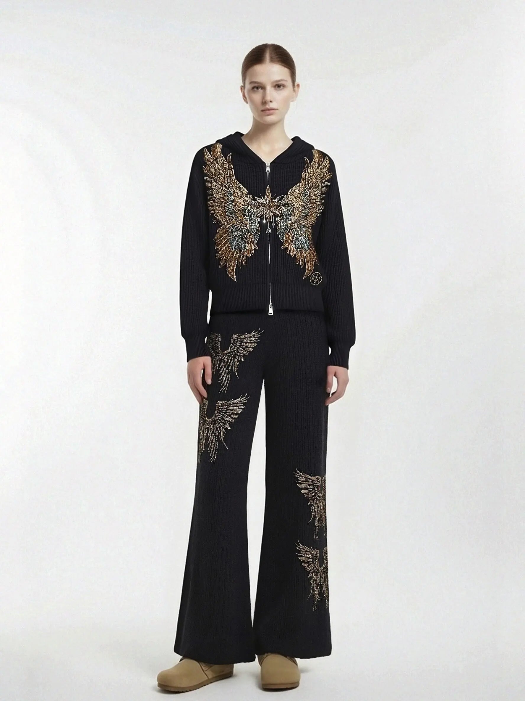 Person wearing a black outfit with embroidered designs on a white background, TCH Rhinestone Angel Wings Zip Hoodie & Flare Pants Set