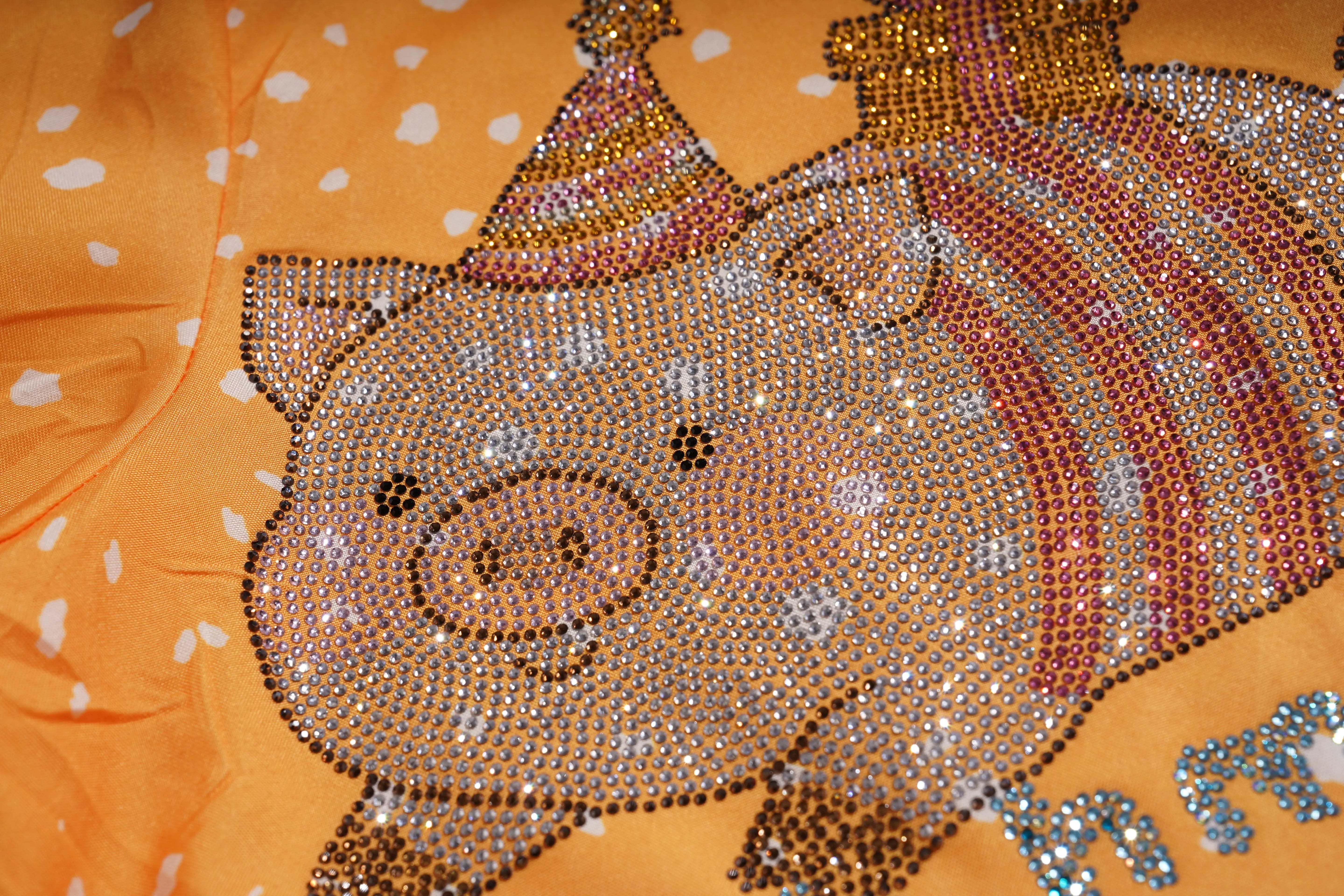 Decorative pig design on fabric with rhinestones against an orange background, TCH Rhinestone Animal Polka Dot Shirt
