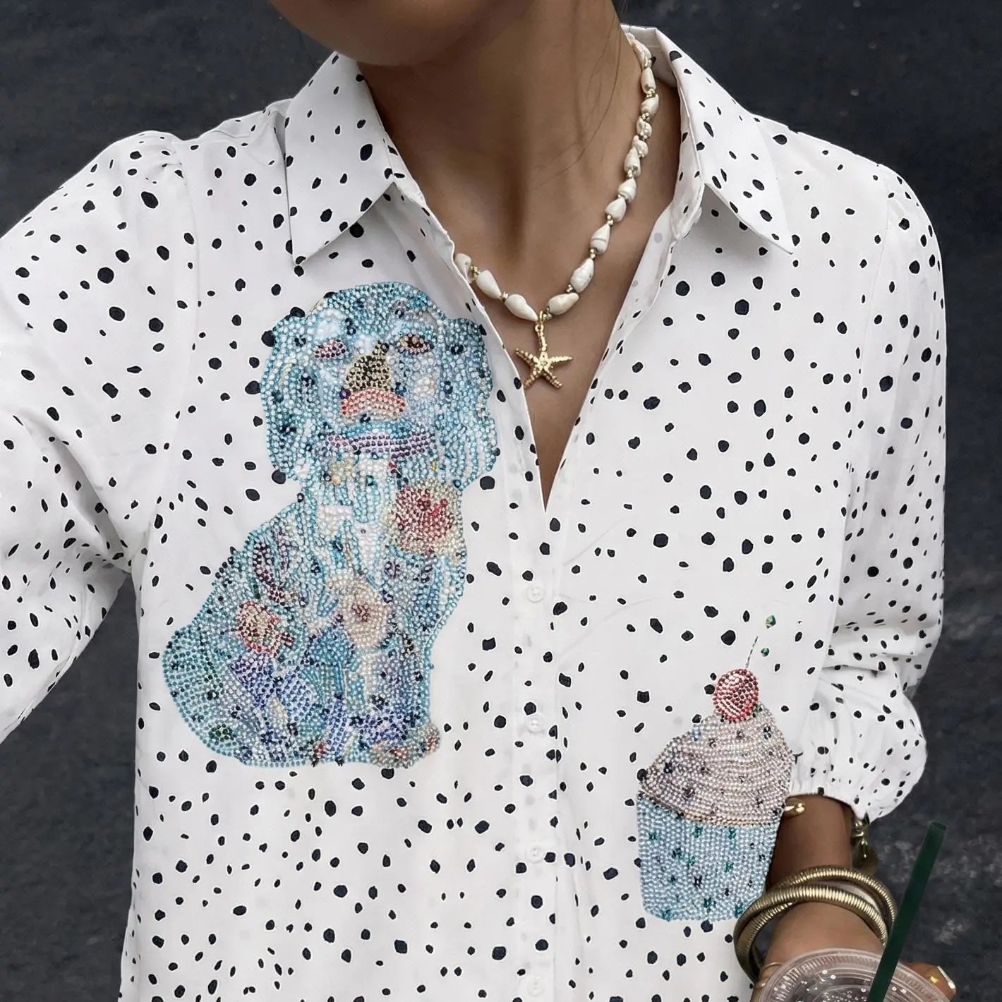 White shirt with black polka dots featuring embroidered dog and cupcake designs, worn by a person. TCH Rhinestone Animal Polka Dot Shirt