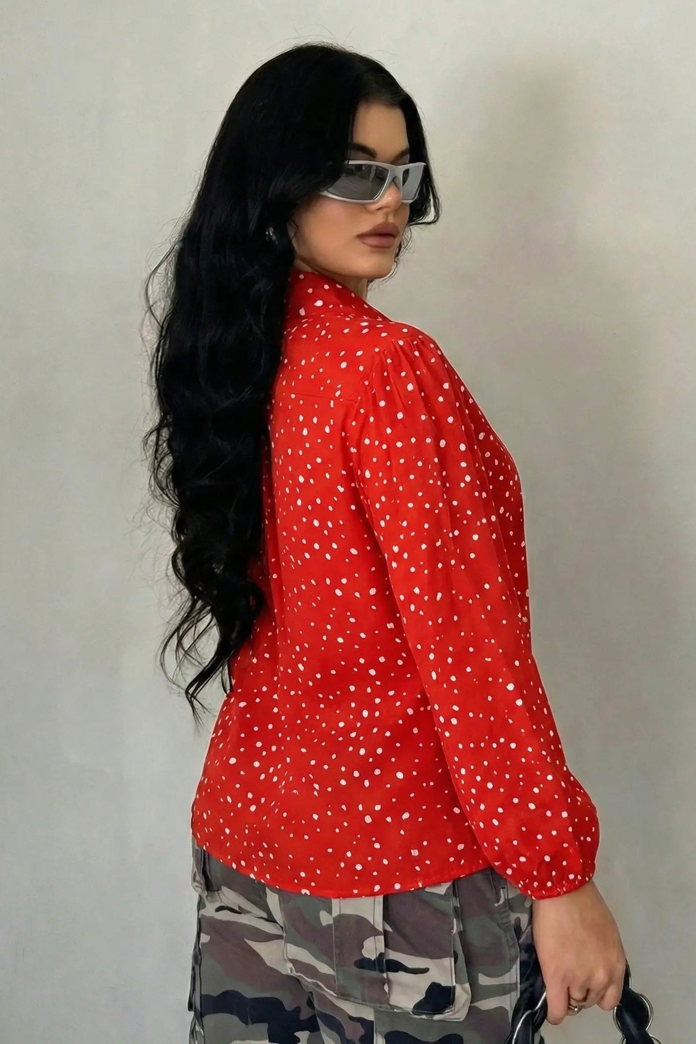 Woman wearing a red polka dot shirt and camouflage pants against a plain background, TCH Rhinestone Animal Polka Dot Shirt