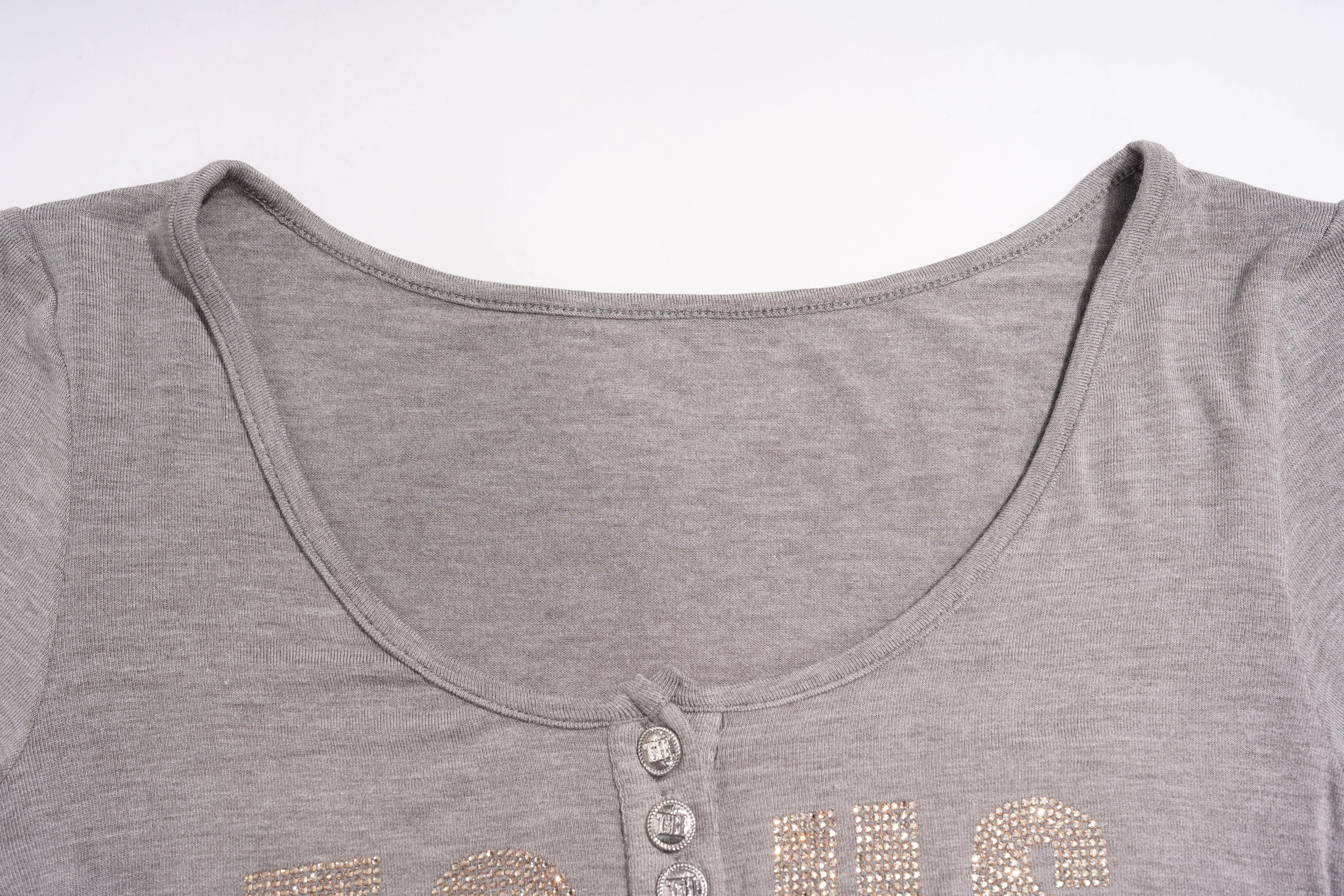Close-up of a heather gray short-sleeve henley top with a scoop neckline and decorative rhinestone lettering across the chest. TCH Rhinestone Bow 3-Piece Lounge Set