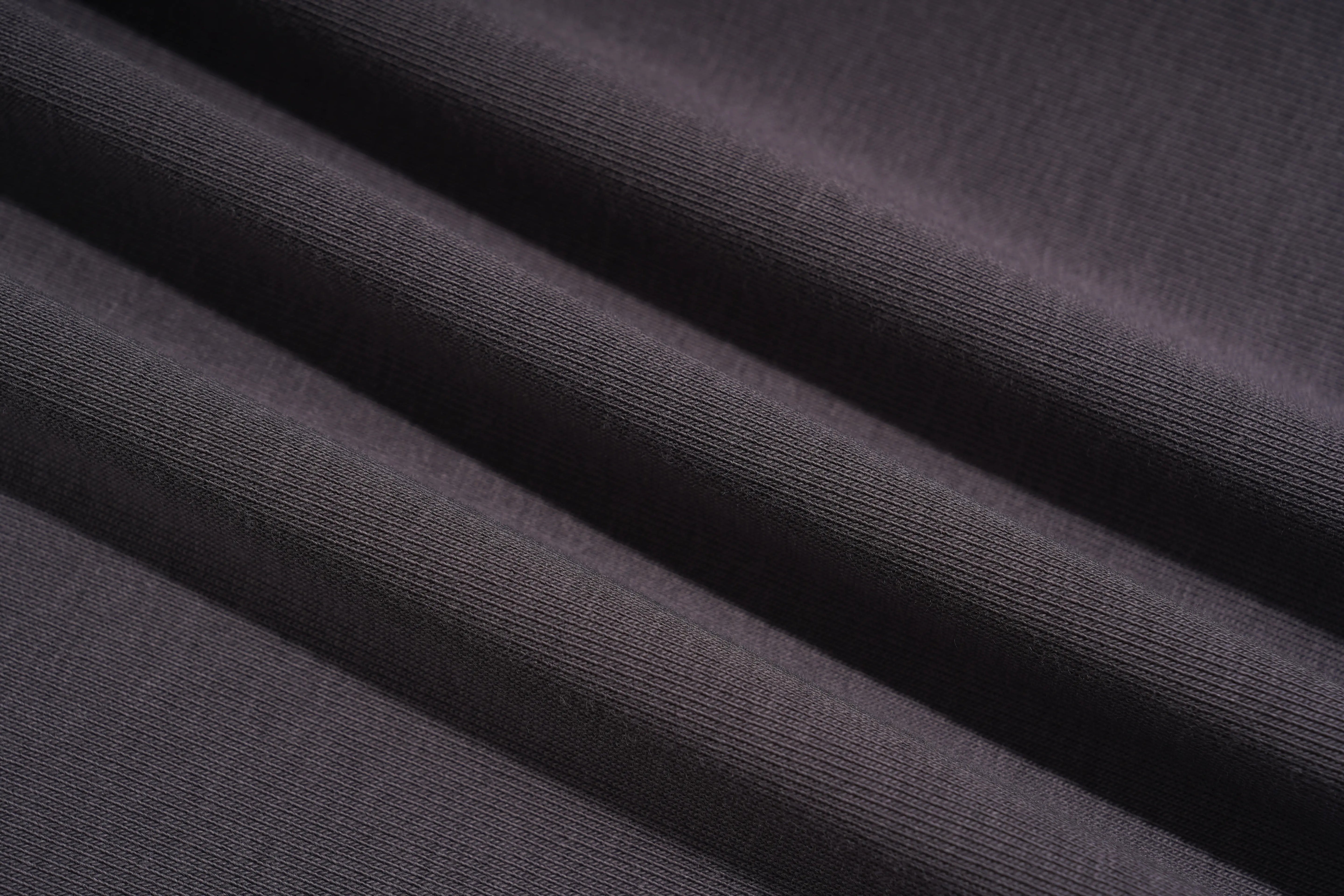 A close-up of dark charcoal gray ribbed fabric with soft diagonal folds showing the texture and weave. TCH Rhinestone Bow Crown Graphic Mini Dress