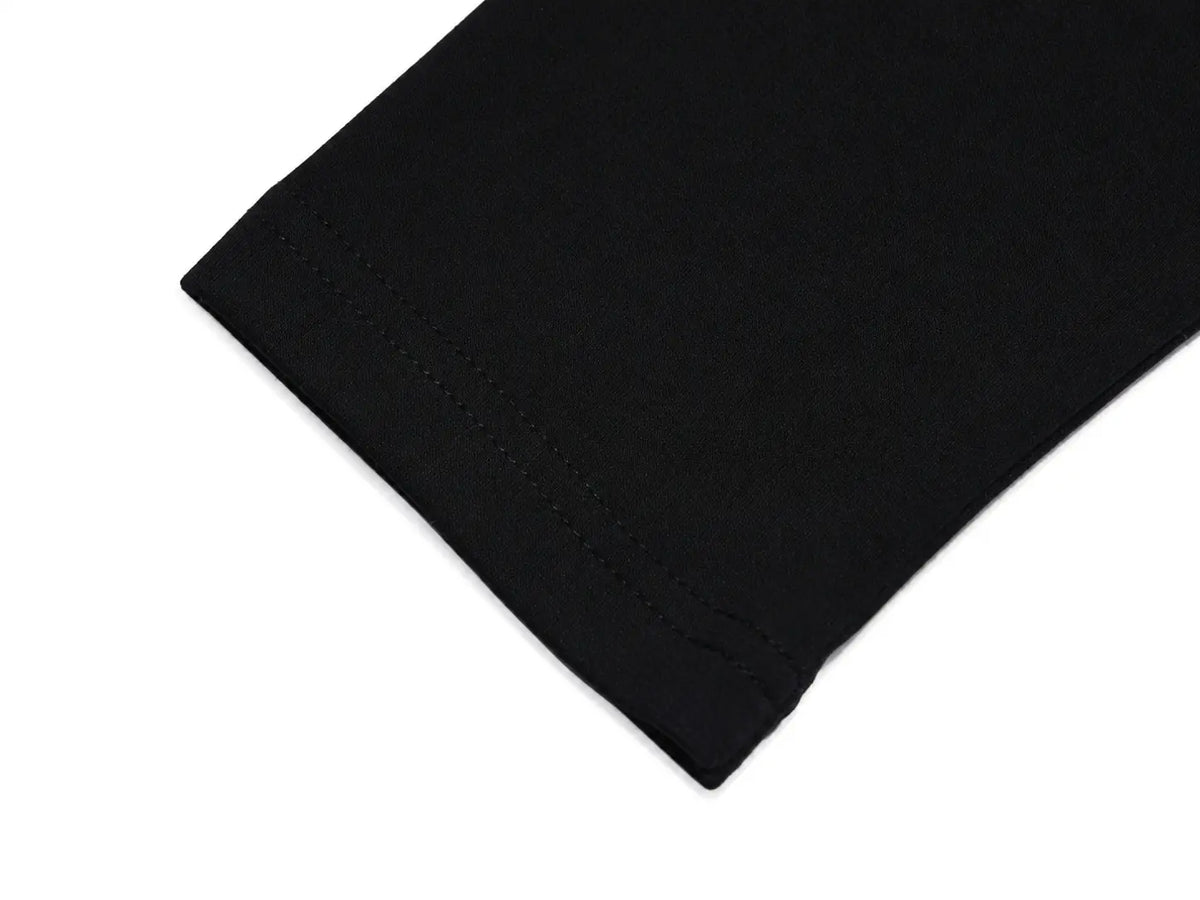 Close-up of a black fabric cuff with neat stitching on a plain white background. TCH Rhinestone Bow Graphic Fitted Long Sleeve Top
