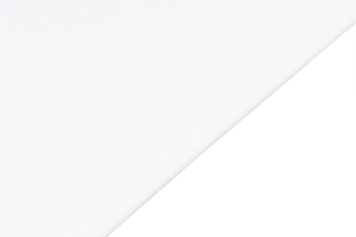 A close-up of a plain white fabric surface with a diagonal fold or edge visible against a white background. TCH Rhinestone Bow Graphic Fitted Long Sleeve Top