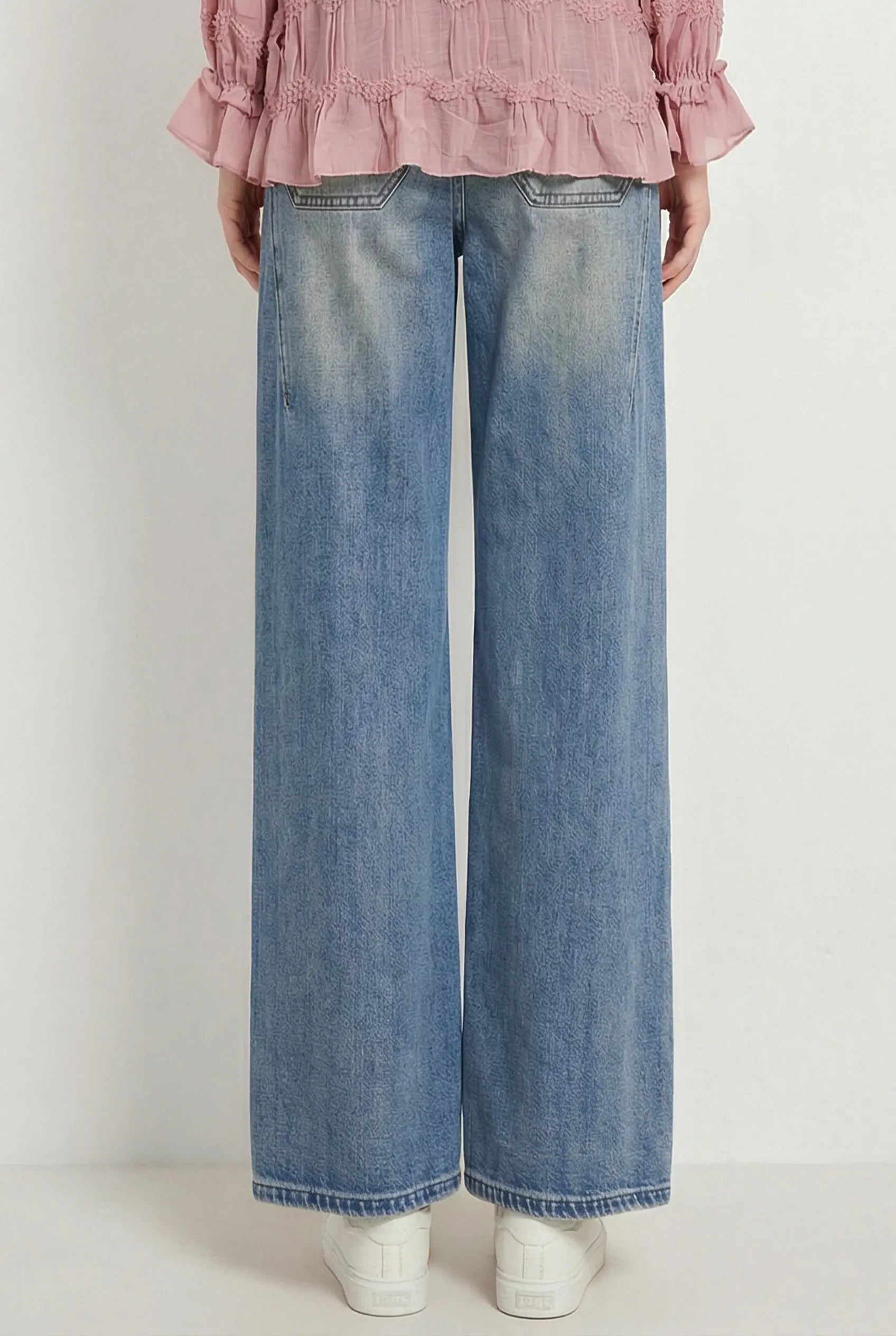 A person shown from the back wearing light blue wide-leg denim jeans, a pink ruffled blouse, and white sneakers against a plain light gray studio background. TCH Rhinestone Bow Lace Side Panel Wide Leg Jeans