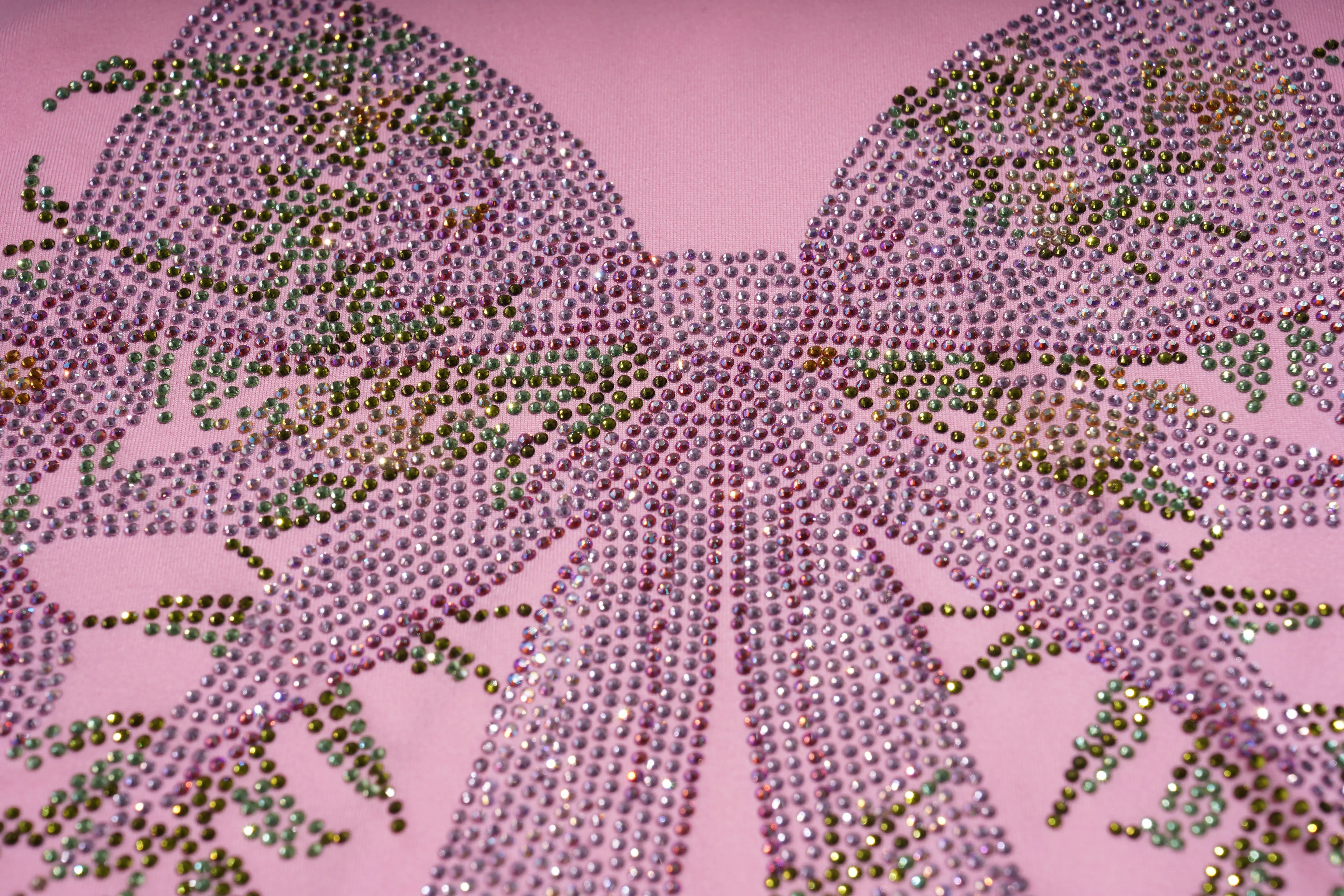 Close-up of a decorative bow with rhinestones on a pink background, TCH Rhinestone Bow & Wing Set