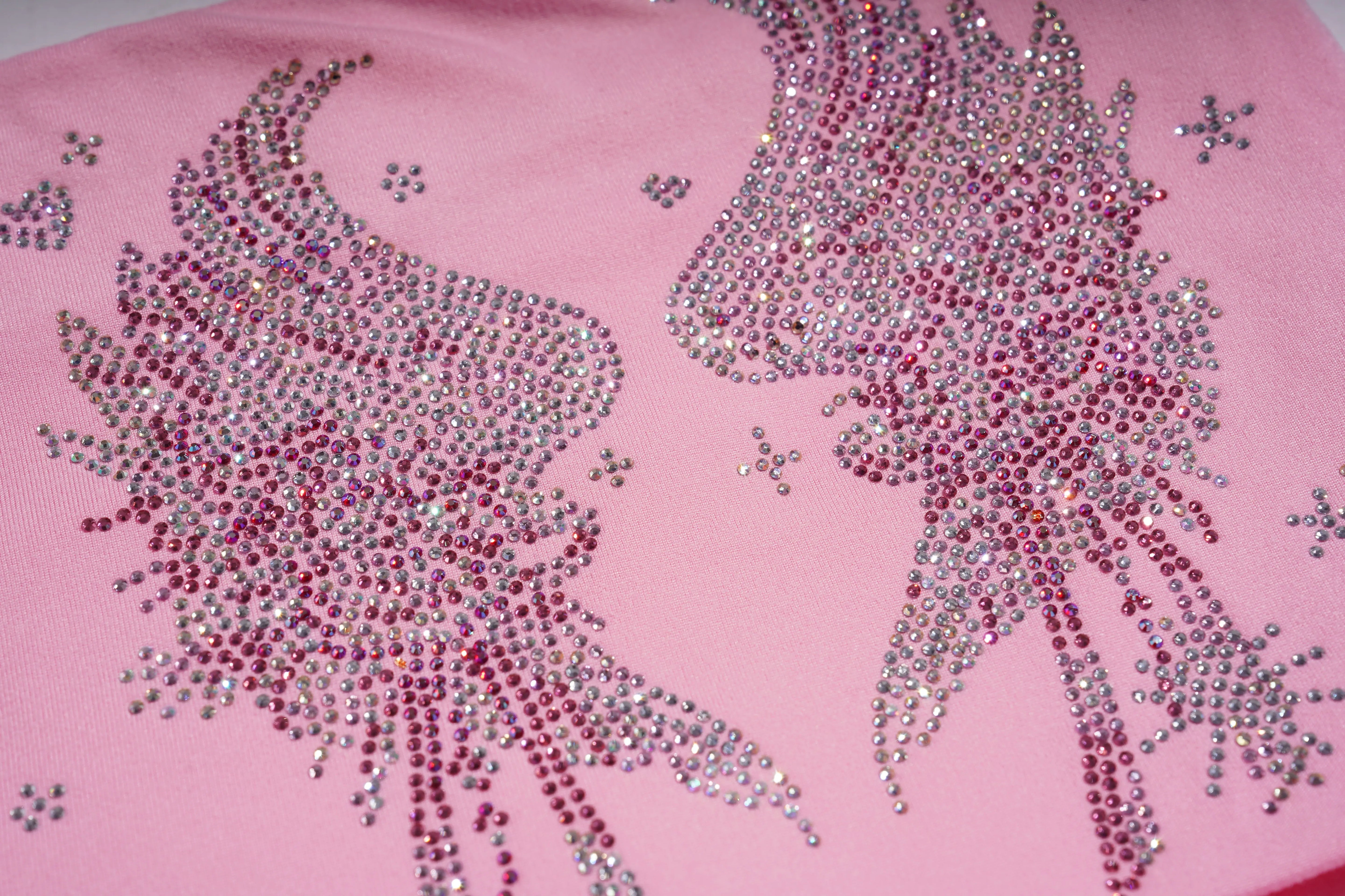 Pink fabric with decorative rhinestone designs on a pink background, TCH Rhinestone Bow & Wing Set