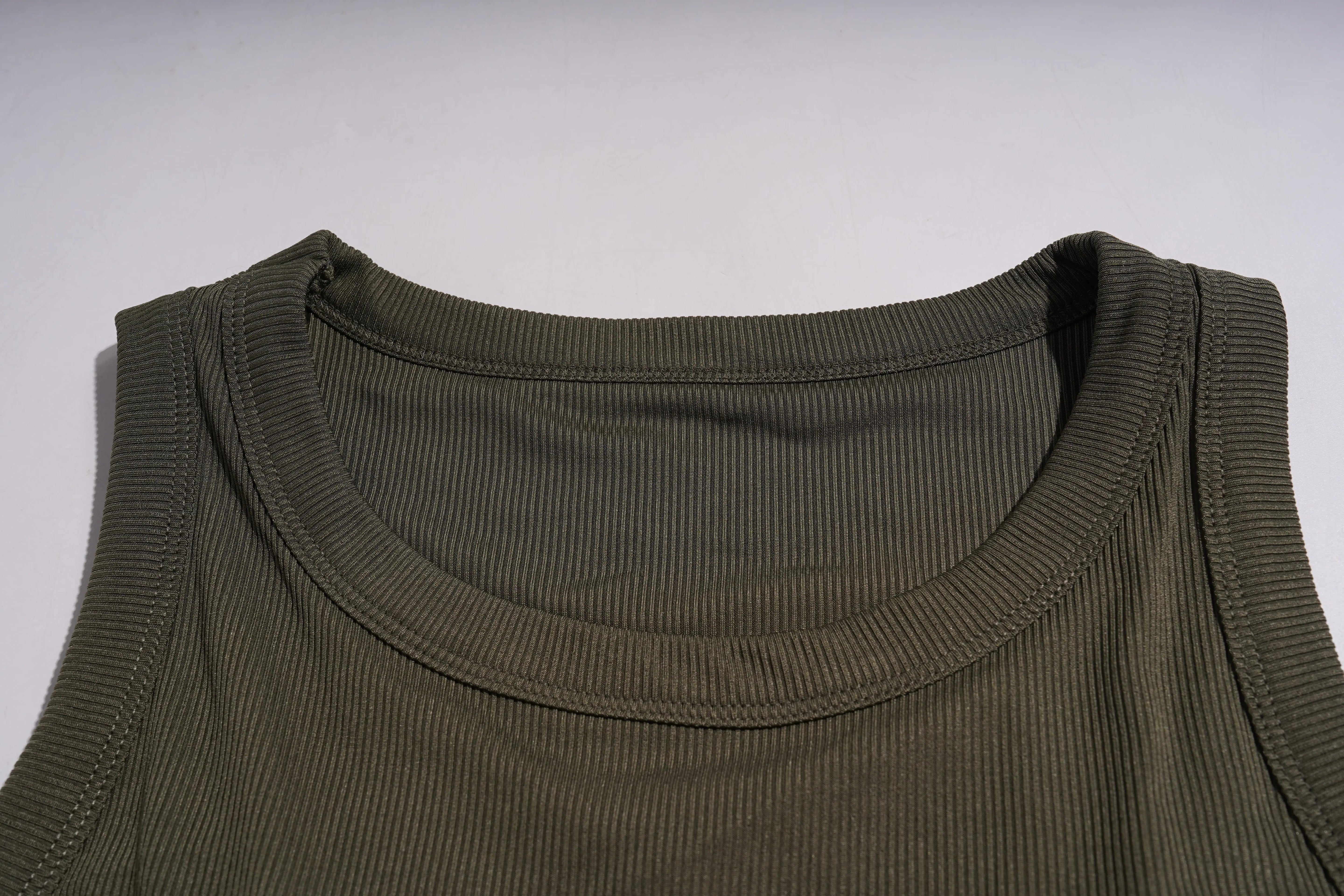 Close-up of a green sleeveless shirt collar on a light gray background, TCH Rhinestone Butterfly Bow Tank Top