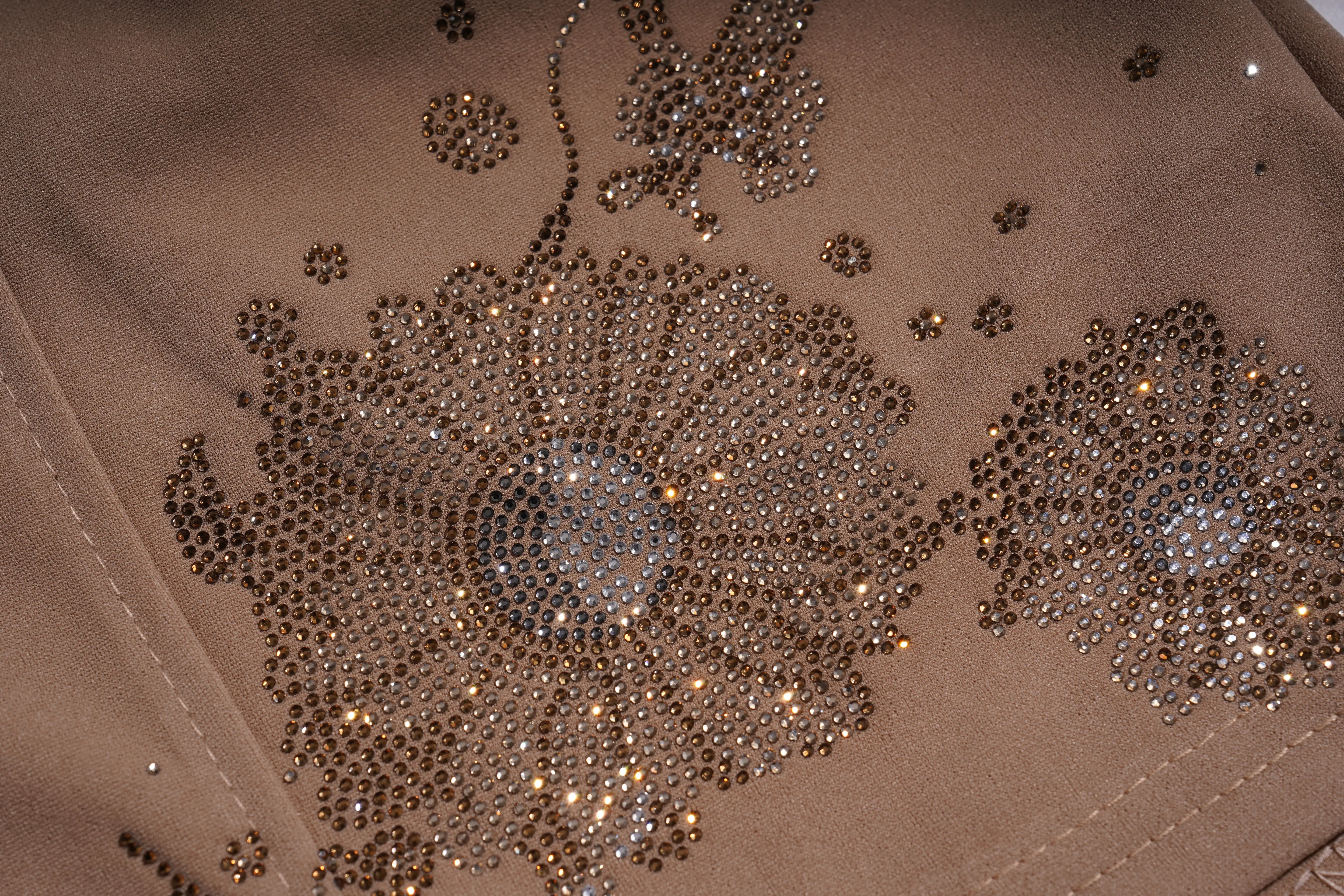 Close-up of a taupe suede or microfiber fabric embellished with large floral patterns made of shimmering rhinestones and sequins. TCH Rhinestone Butterfly Floral Embellished Tailored Shorts