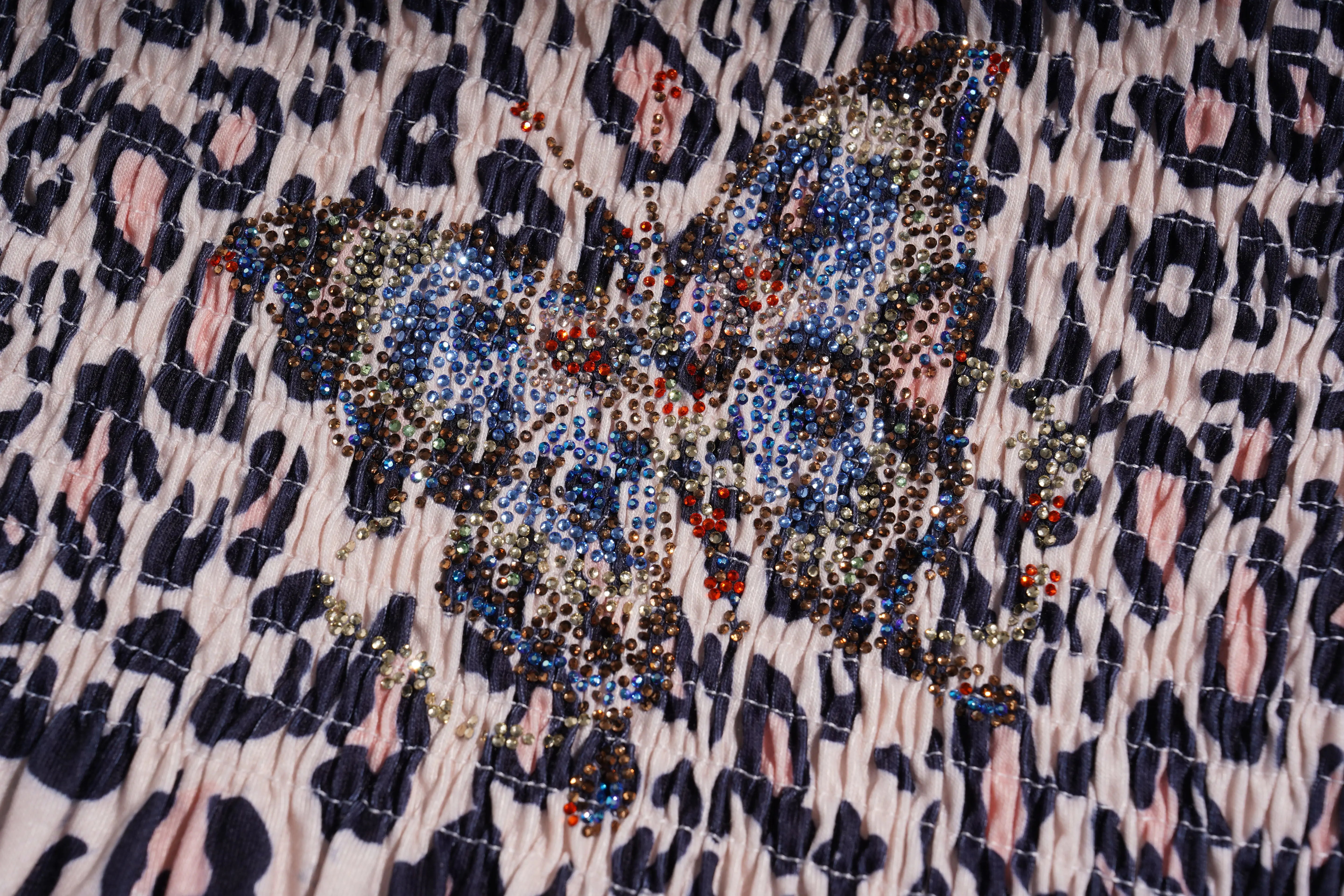 Close-up of a patterned fabric with a butterfly design and leopard print background, TCH Rhinestone Butterfly & Floral Leopard Tube Top
