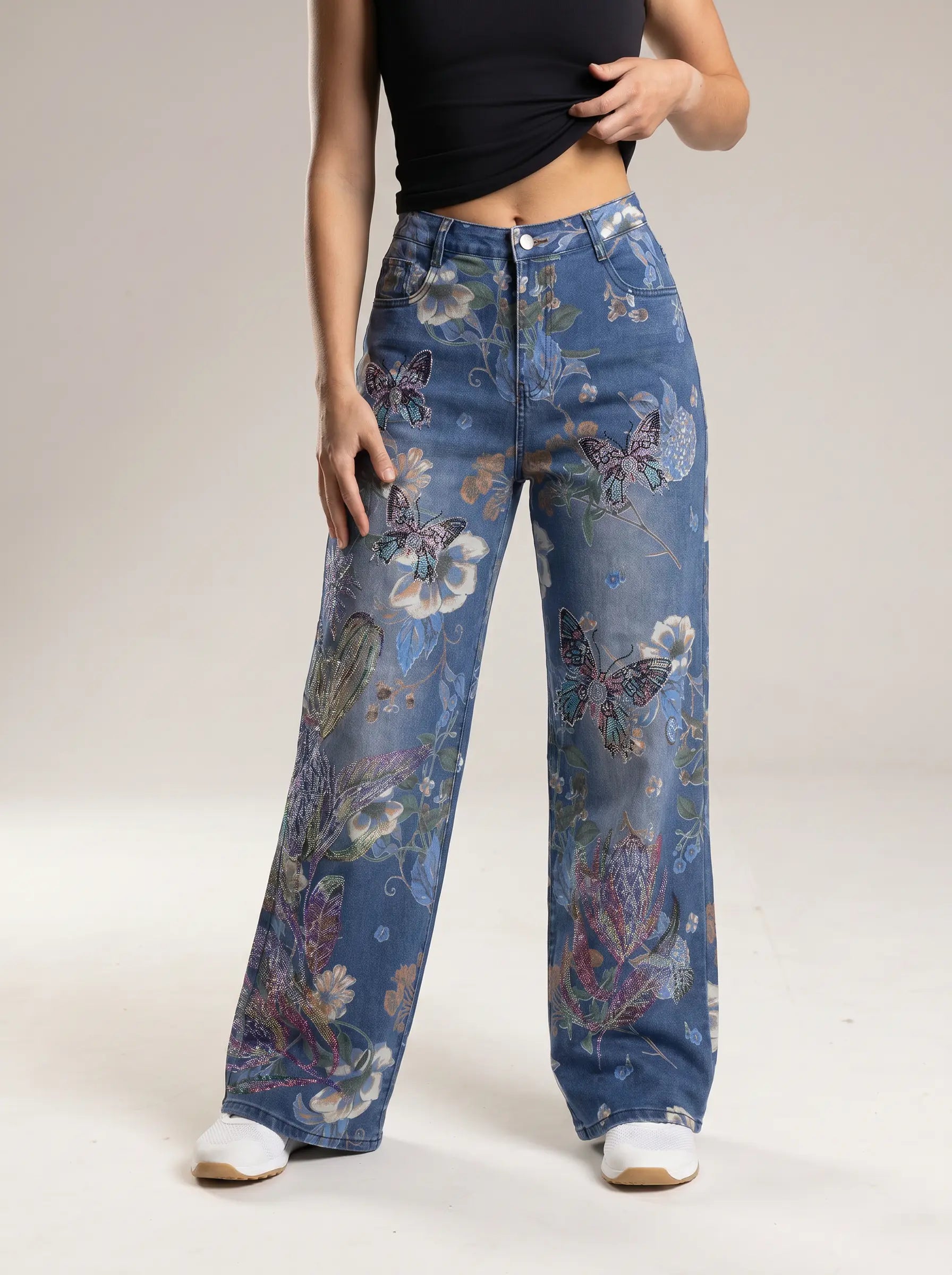 Person wearing blue floral-patterned jeans on a white background, TCH Rhinestone Butterfly Floral Print Denim Jeans