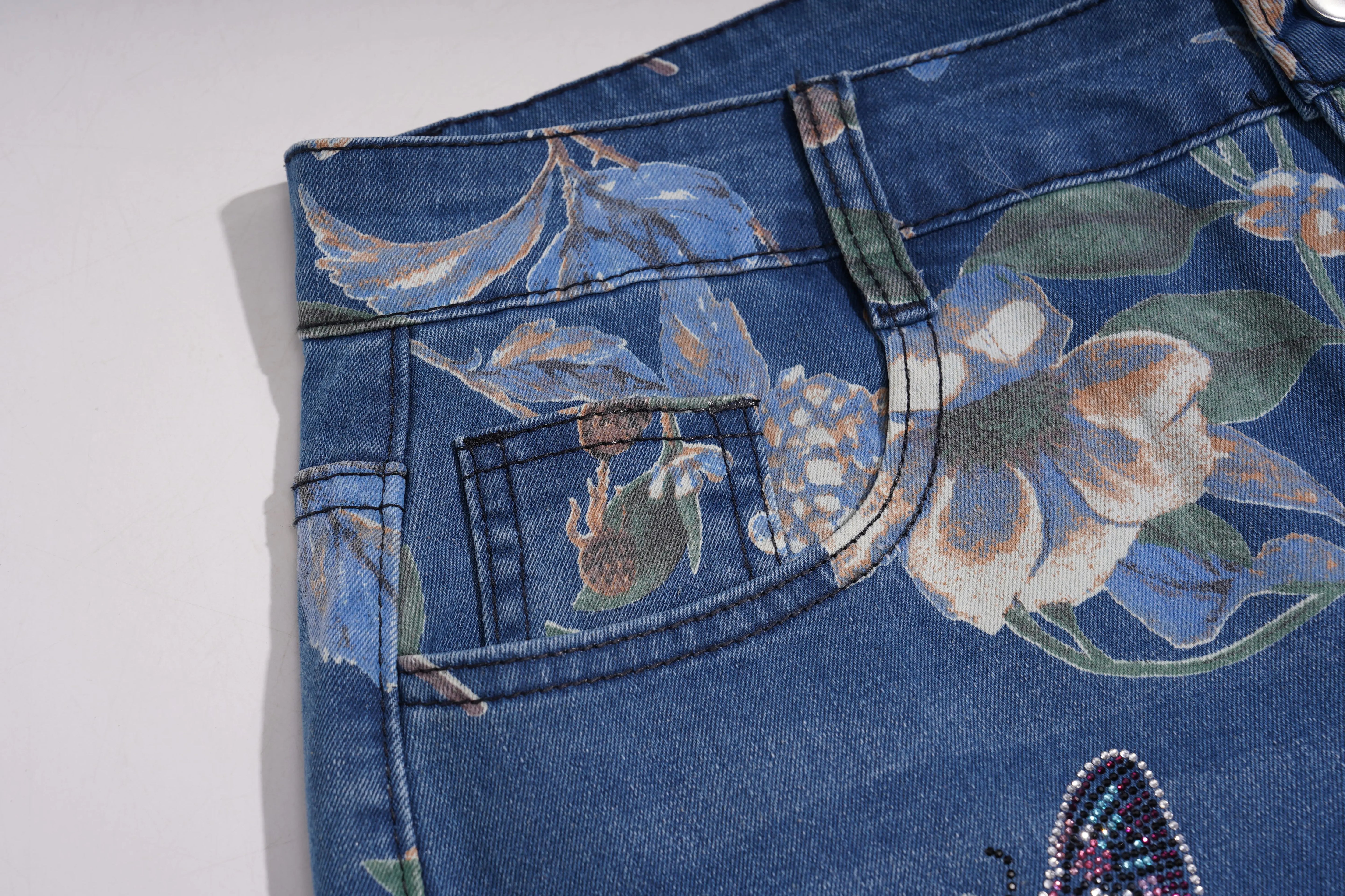 Close-up of blue jeans with floral embroidery on a white background, TCH Rhinestone Butterfly Floral Print Denim Jeans