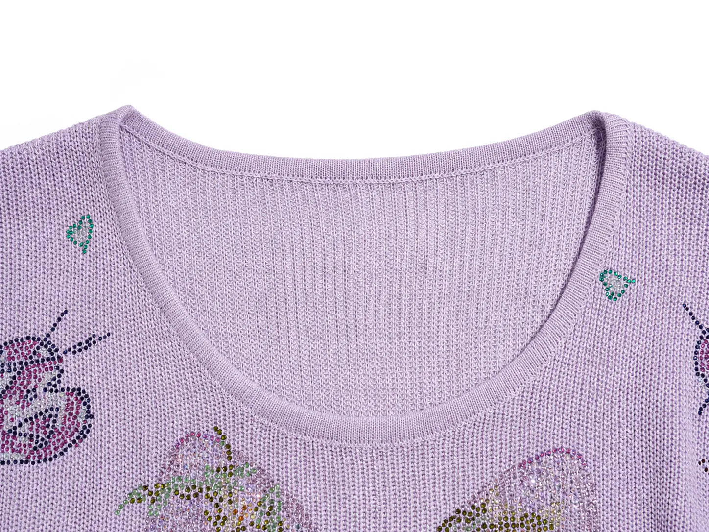 Close-up of a light purple knit sweater with rhinestone butterfly and floral embellishments on a white background. TCH Rhinestone Butterfly Knit Twist Top
