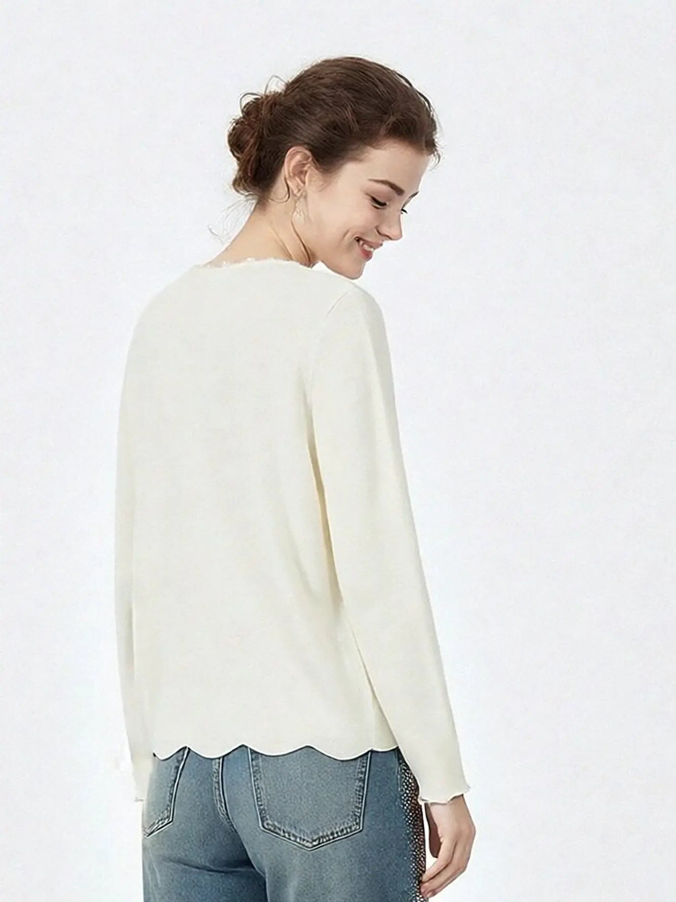 Woman wearing a white sweater and blue jeans on a white background, TCH Rhinestone Butterfly Logo Knit Cardigan