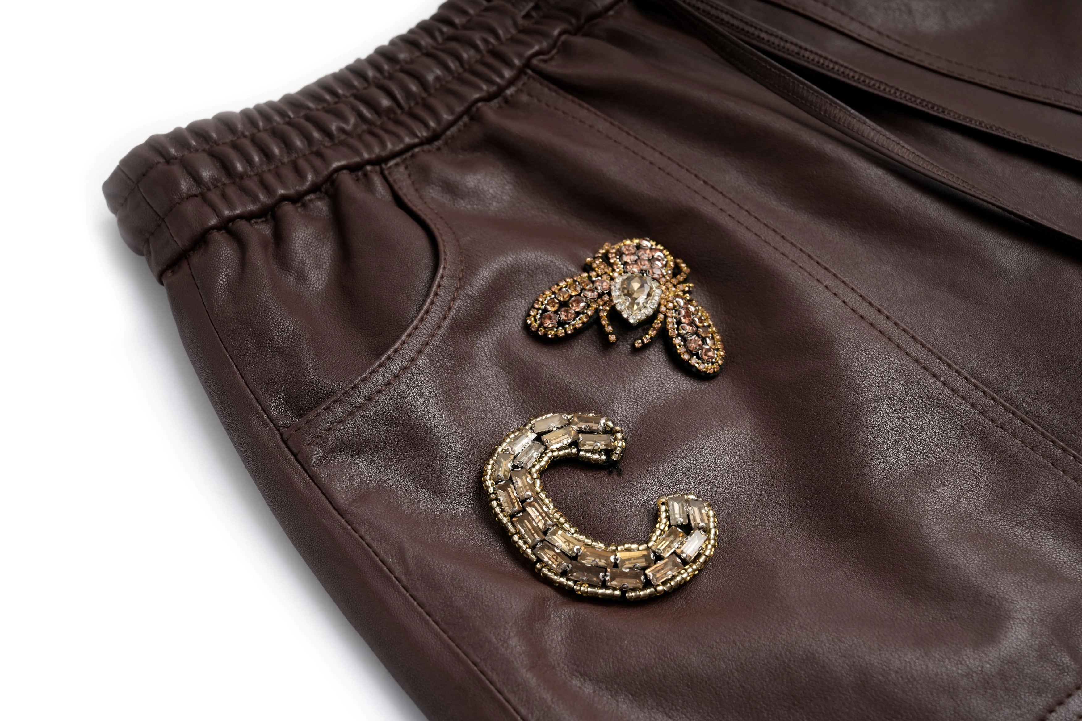 Brown leather jacket with decorative bee and snake patches on a white background, TCH Rhinestone Charm Faux Leather Brown Shorts