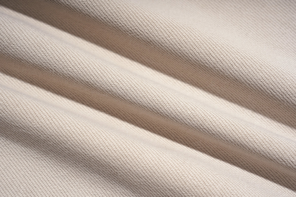 Close-up of a woven fabric with soft diagonal folds and shadows, showing a light warm neutral color. TCH Rhinestone Cherry Blossom Straight-Leg Jeans