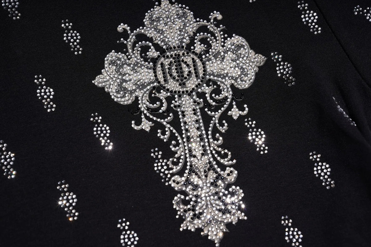 A close-up of a black garment featuring a large ornate silver rhinestone cross motif on the chest, with smaller scattered rhinestone dot patterns on the fabric. TCH Rhinestone Cross Graphic Fitted Long Sleeve Top