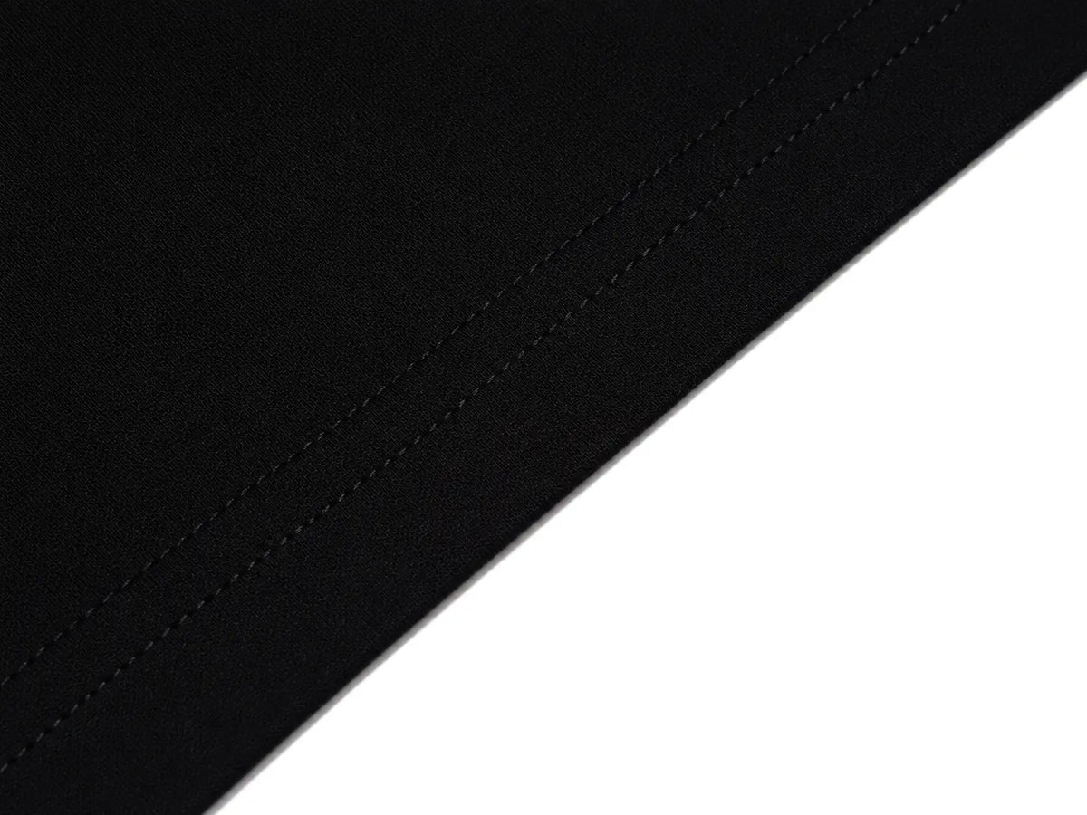 Close-up of a black fabric surface with fine diagonal stitching, shown against a white background. TCH Rhinestone Cross Pattern Black Long Sleeve T-Shirt