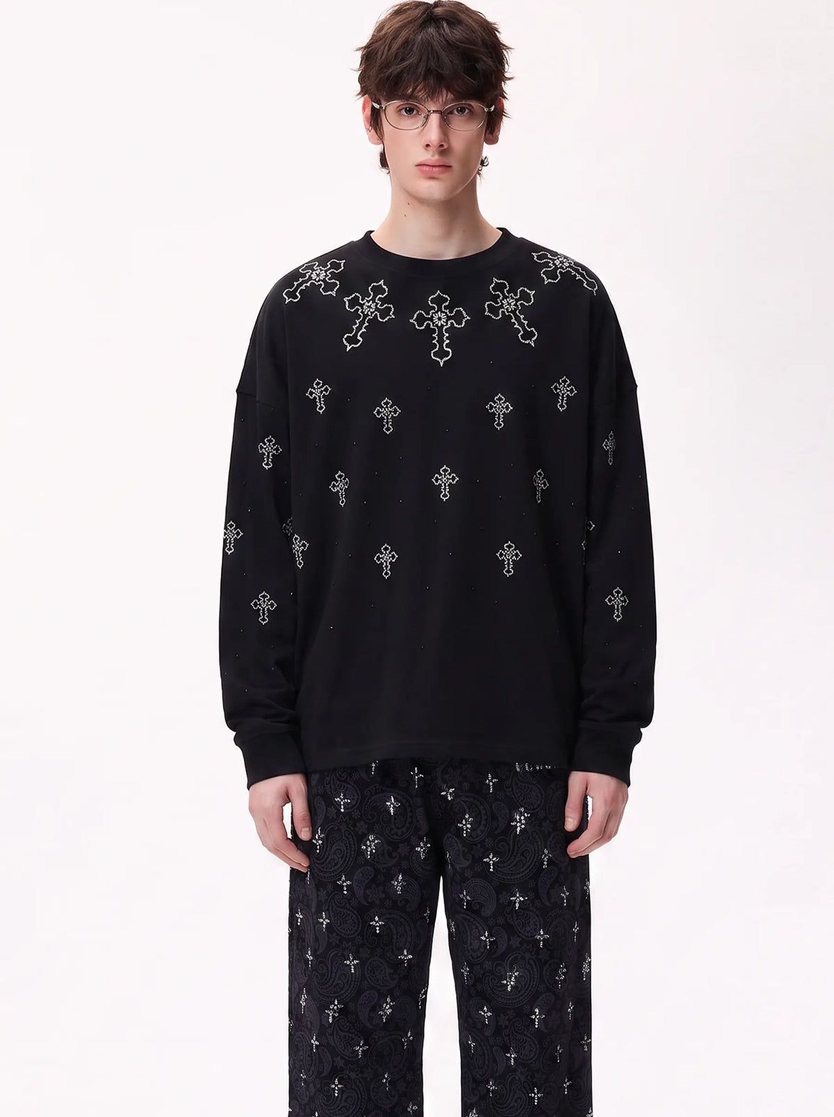 A model wearing a black long-sleeve crewneck sweatshirt with white embroidered crosses, paired with matching black patterned pants, against a plain white studio background. TCH Rhinestone Cross Pattern Black Long Sleeve T-Shirt