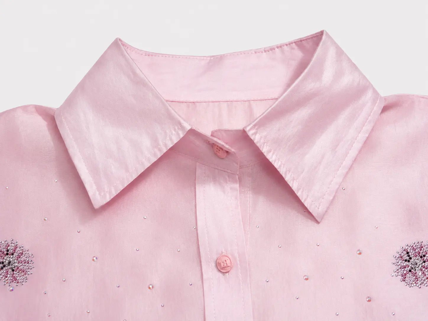 Close-up of a light pink collared button-up shirt with small rhinestone embellishments and embroidered floral details on the chest, shown against a plain light background. TCH Rhinestone Crystal Embellished Pink Shirt & Shorts Set