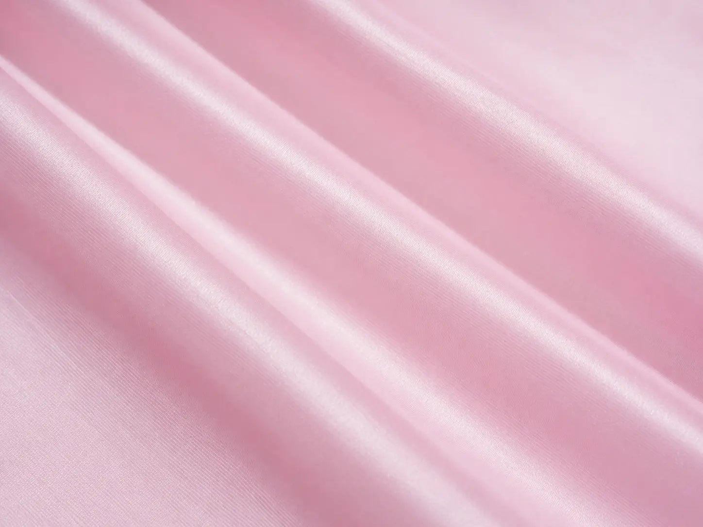 A close-up of draped light pink satin or silk fabric with soft diagonal folds and a subtle sheen. TCH Rhinestone Crystal Embellished Pink Shirt & Shorts Set