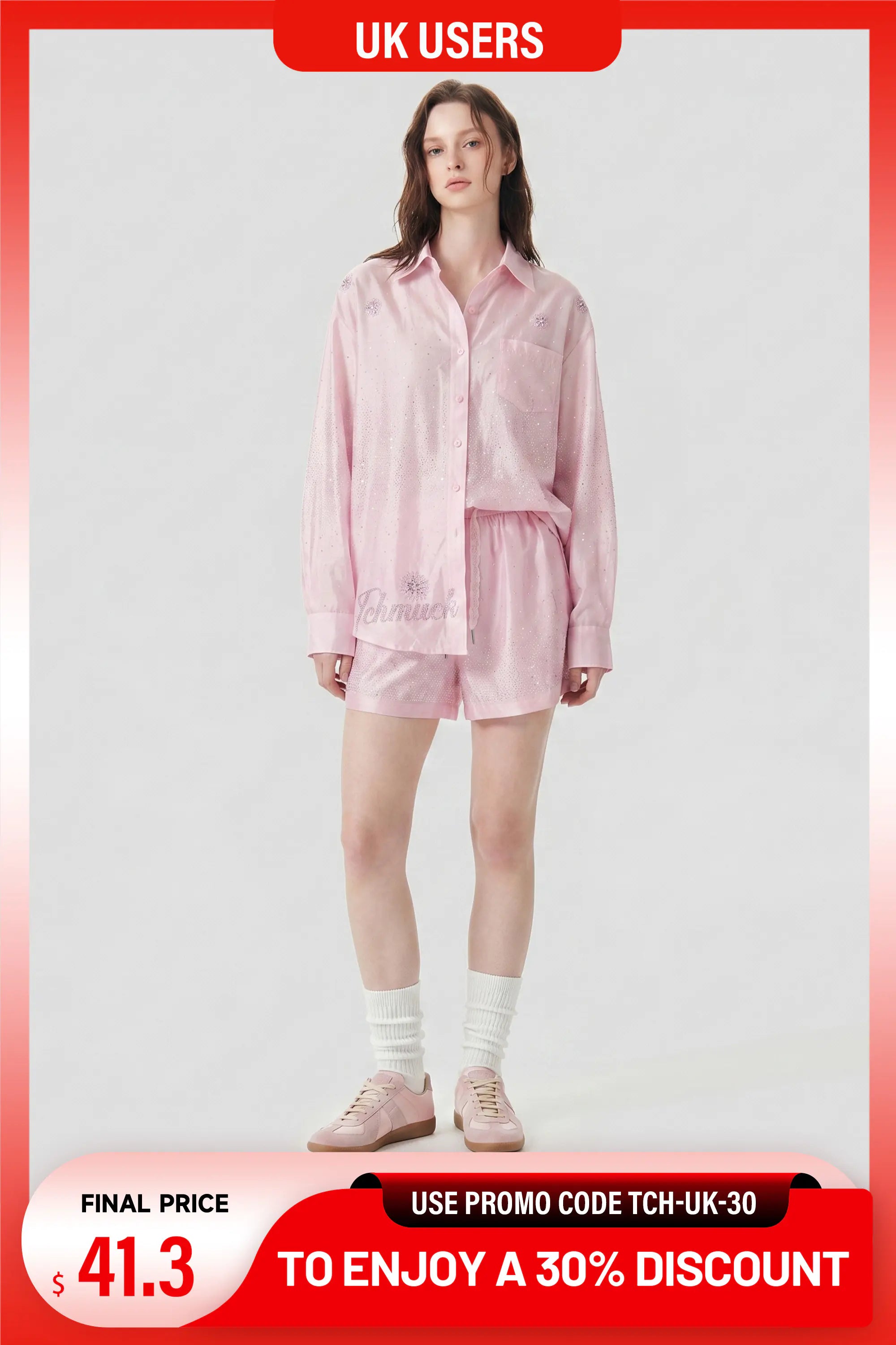 A model wearing a light pink matching lounge set consisting of a long-sleeve button-up shirt and shorts, styled with white socks and pink sneakers, set against a plain light gray background with promotional text overlays. TCH Rhinestone Crystal Embellished Pink Shirt & Shorts Set
