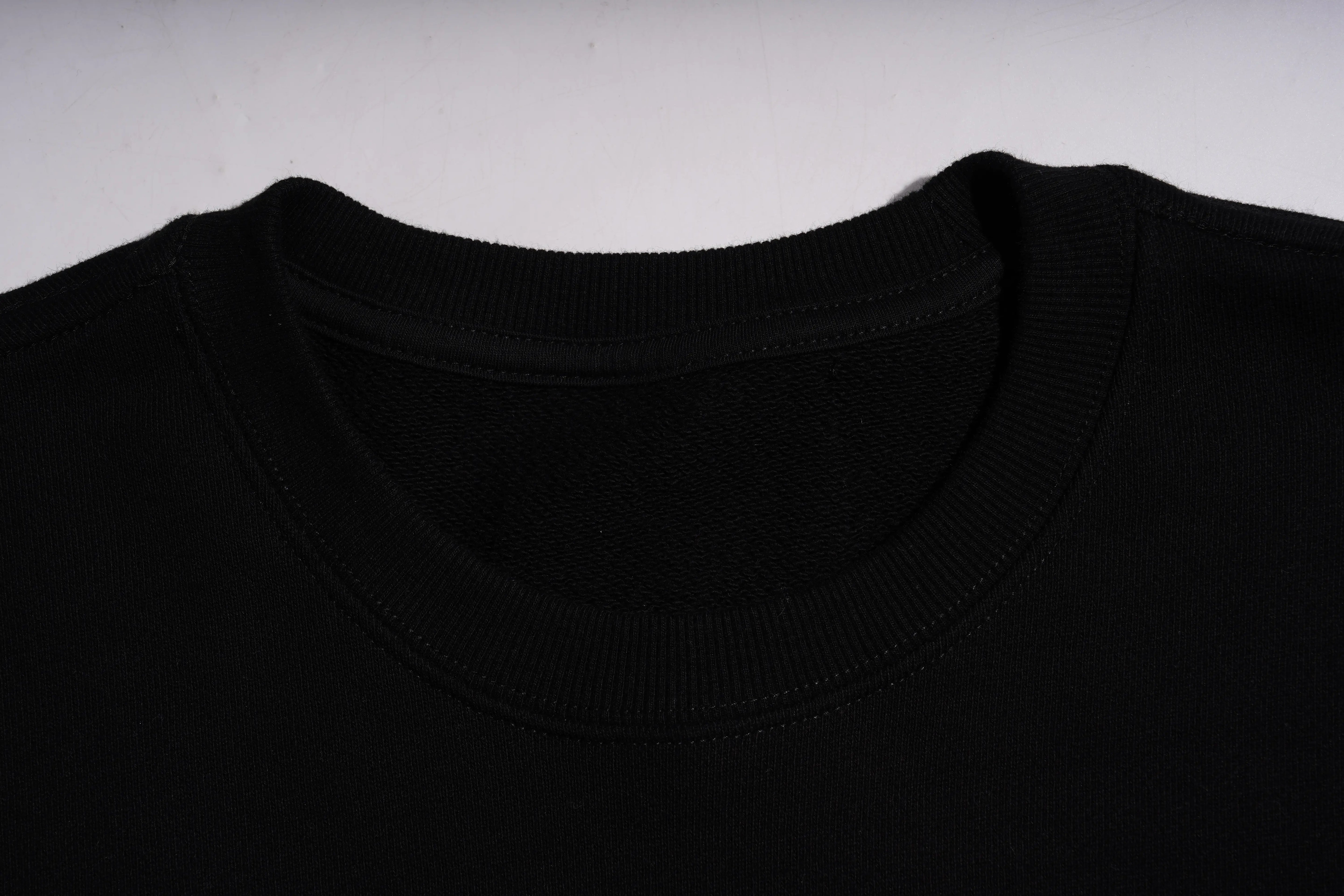 Close-up of a black sweater collar on a light gray background， TCH Rhinestone Cute Dragon Sweatshirt-