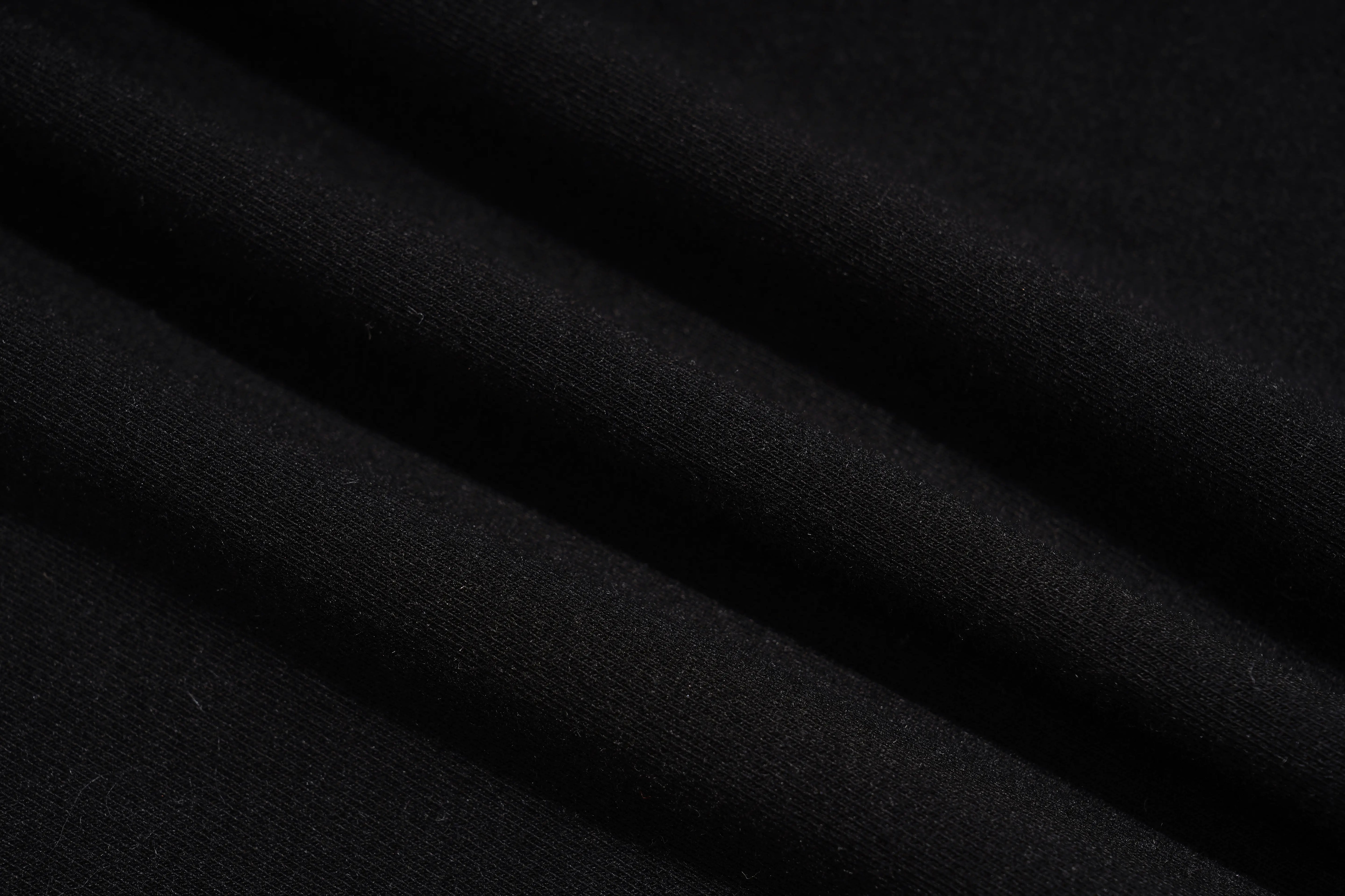 A close-up of draped black fabric with soft folds showing a fine knit texture. TCH Rhinestone Deer Graphic Mesh Sleeve Black Streetwear T-Shirt