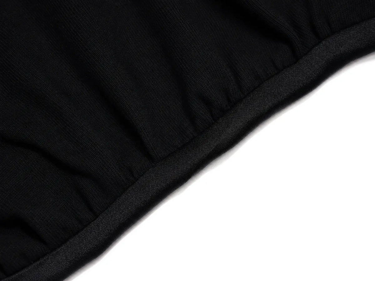 Close-up of a black ribbed knit fabric, likely a beanie or sweater cuff, shown diagonally against a plain white background. TCH Rhinestone Denim Corset Graphic Oversized T-Shirt
