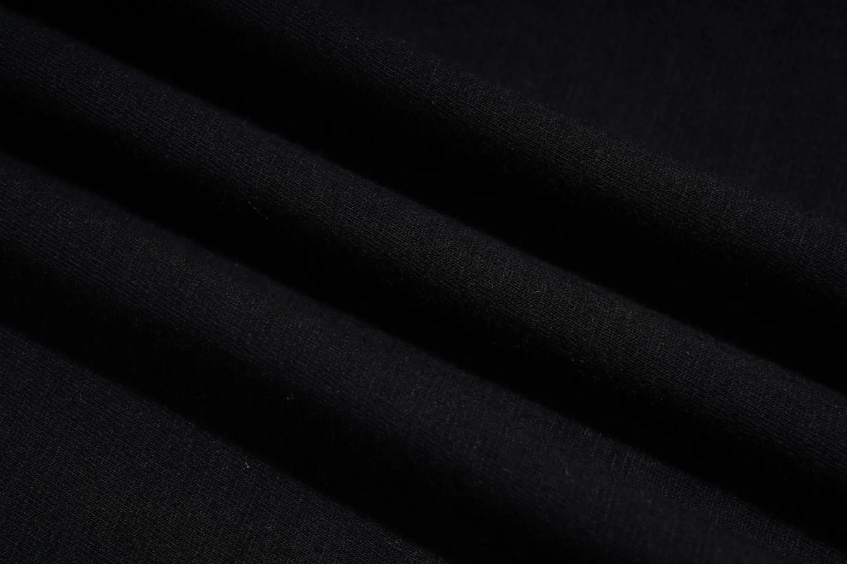 A close-up of draped black fabric with soft folds showing a fine knit texture. TCH Rhinestone Firework Graphic Black Sweatshirt