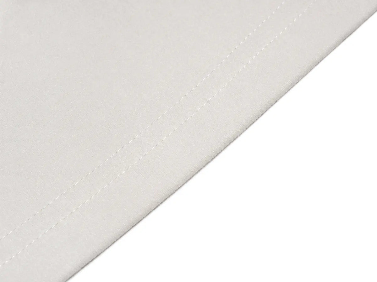 A close-up of a white fabric surface with a diagonal stitched seam, shown against a white background. TCH Rhinestone Fleur-de-Lis Fitted Long Sleeve Top