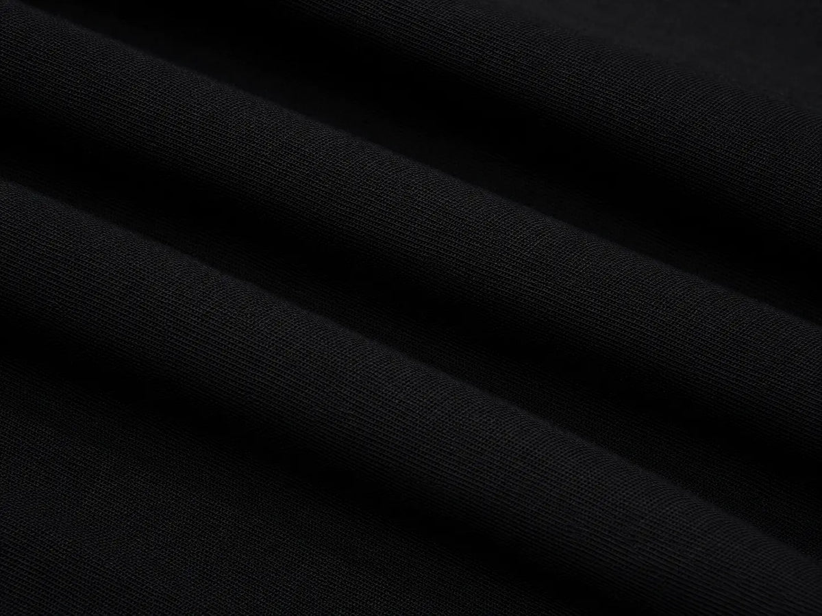 A close-up of black fabric with soft diagonal folds showing a fine knit texture. TCH Rhinestone Fleur-de-Lis Fitted Long Sleeve Top